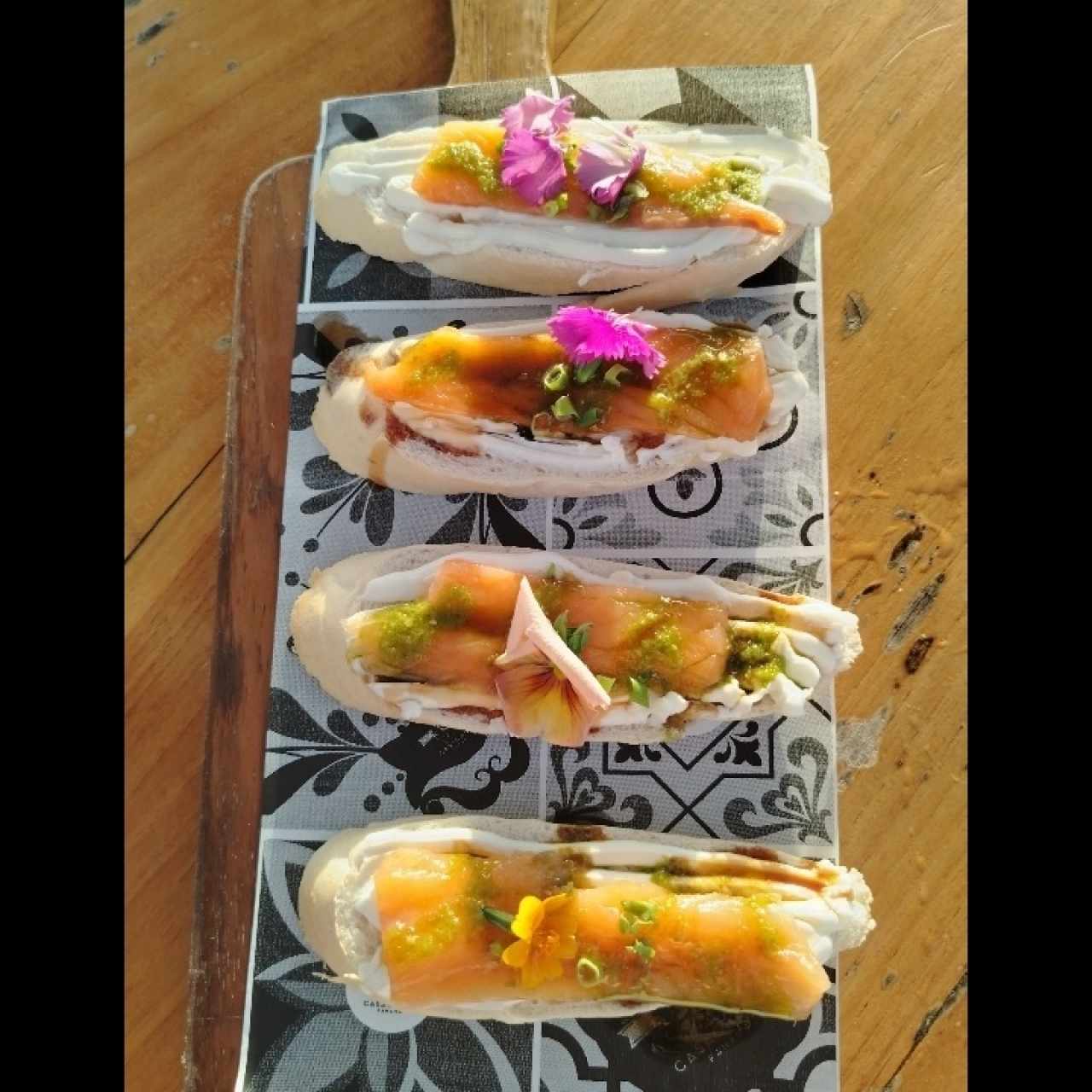 4 Crostini de salmón fresco, pesto de aceitunas, microgreens y queso crema.