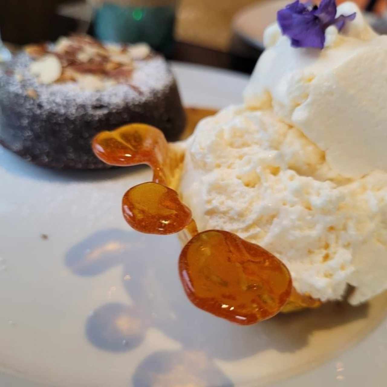 FONDANT DE CHOCOLATE (Bizcocho de Chocolate con Centro Fundido Acompañado con Helado sobre Canasta de Caramelo, Almendras Fileteadas y Reducción de Frutos Rojos) 