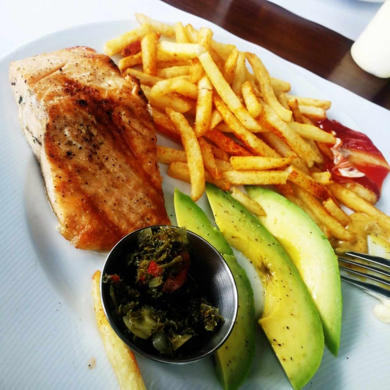 salmón al carbón acompañado de papas y aguacate