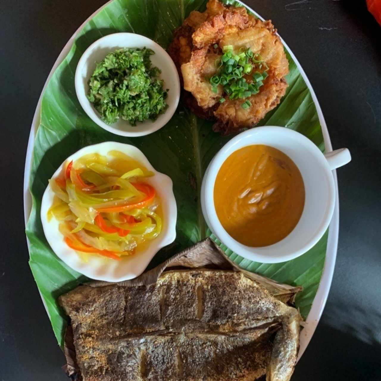 corvina con escabeche, salsa de tamal de olla, un ajillo y patacones