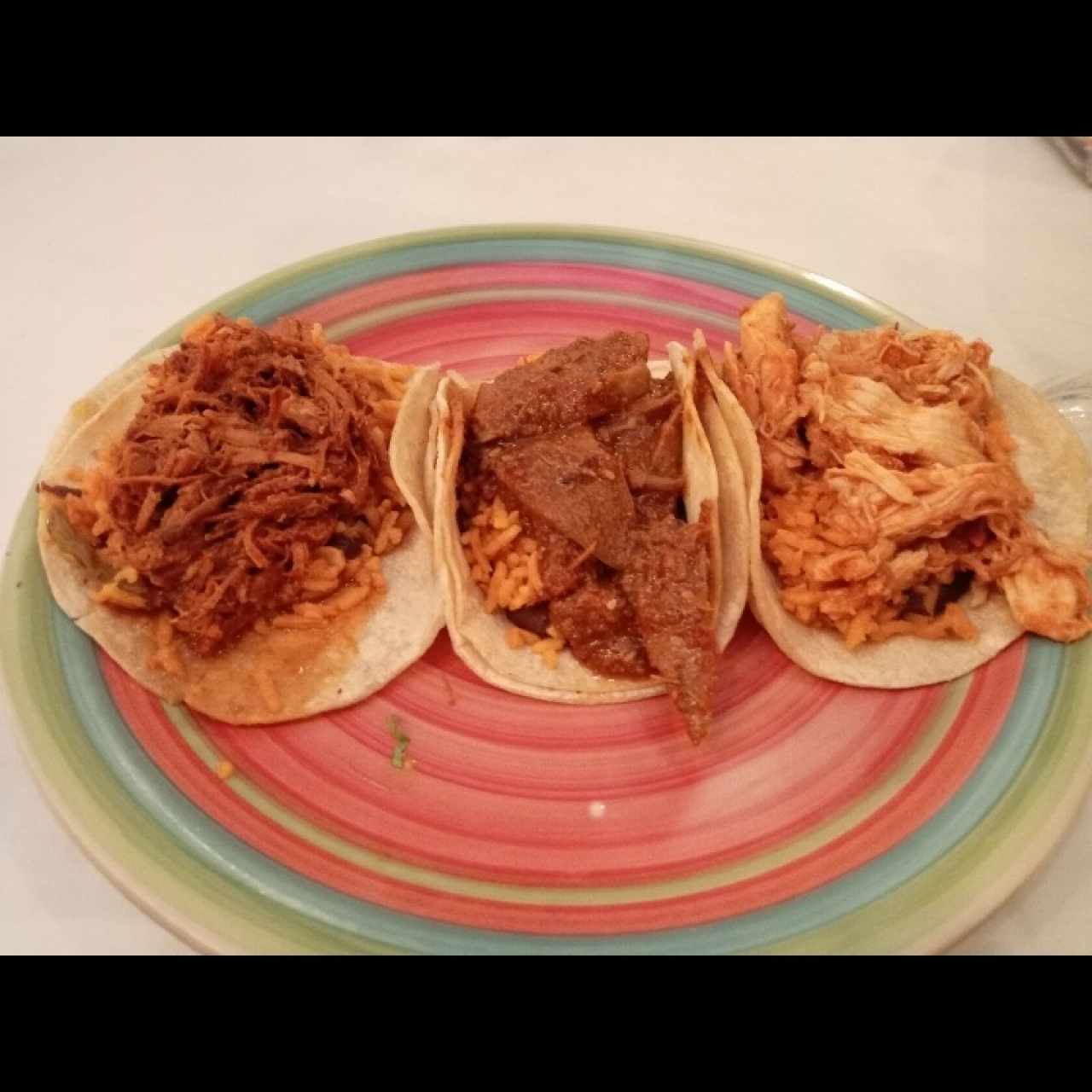 Taco de cochinita pibill, lengua en salsa roja y tina de pollo
