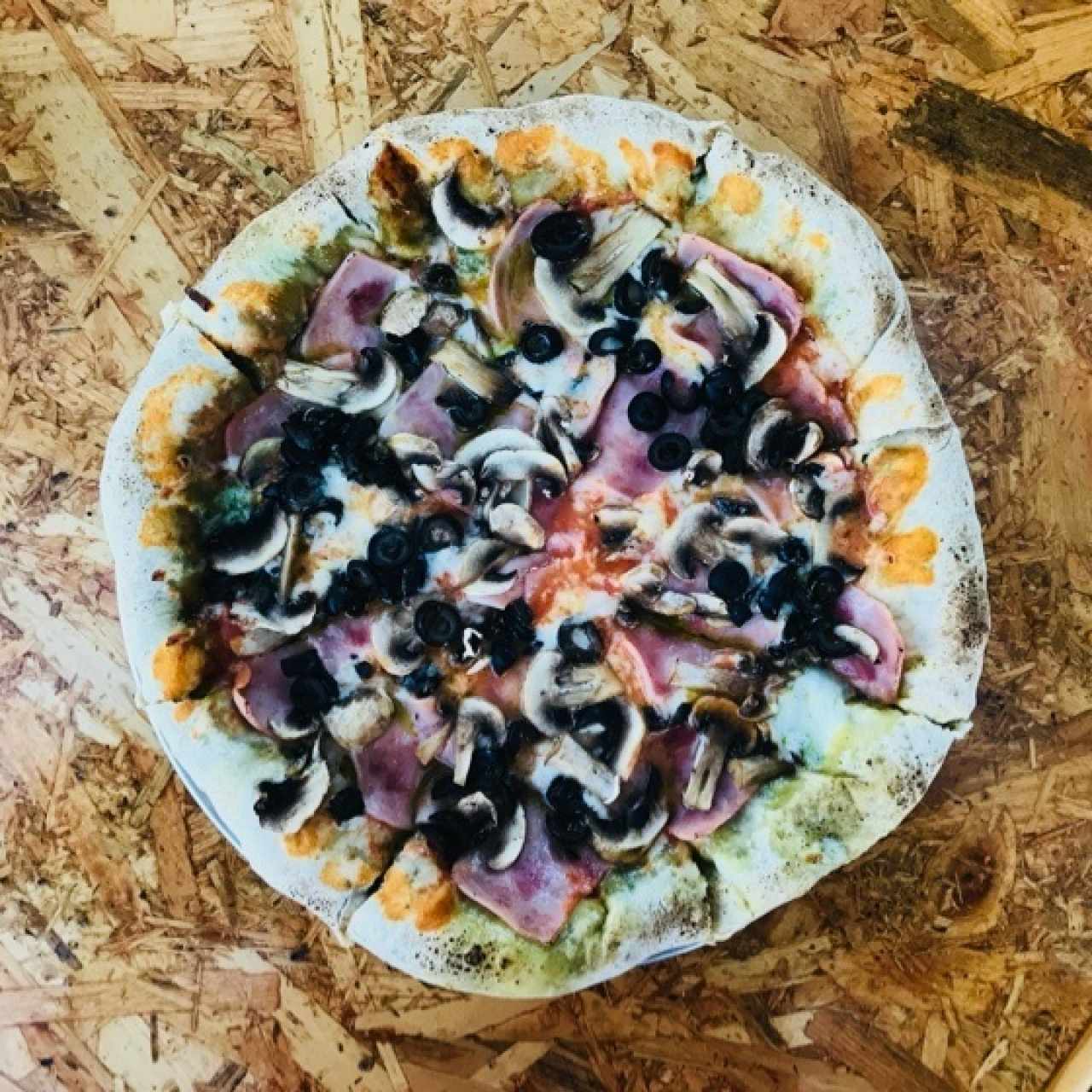 Pizza jamón y champiñones con extra de queso y pesto