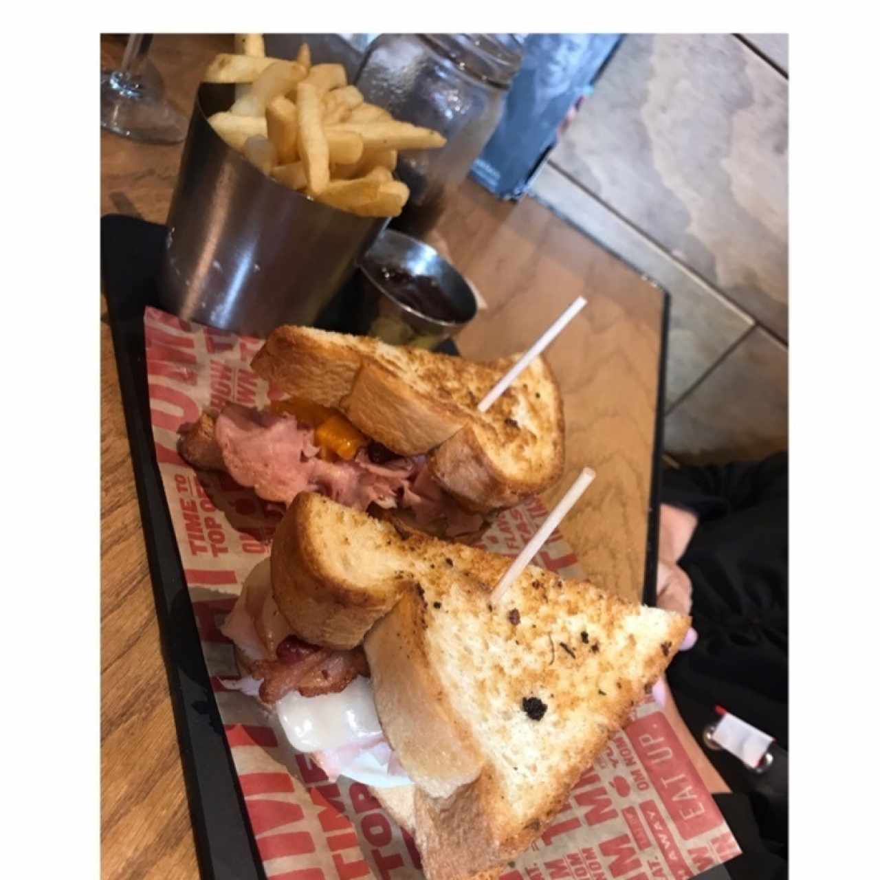 Emparedado de bacon, huevo y jamón con side de papas fritas