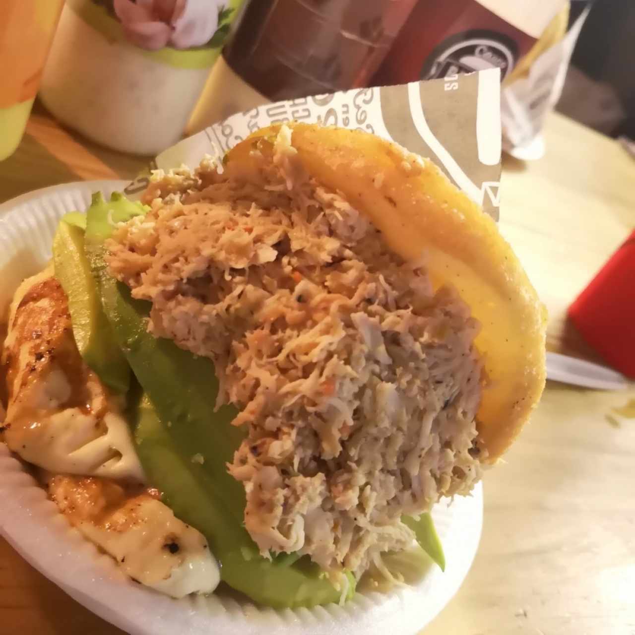 Arepa: pollo desechado, aguacate y queso a la plancha 