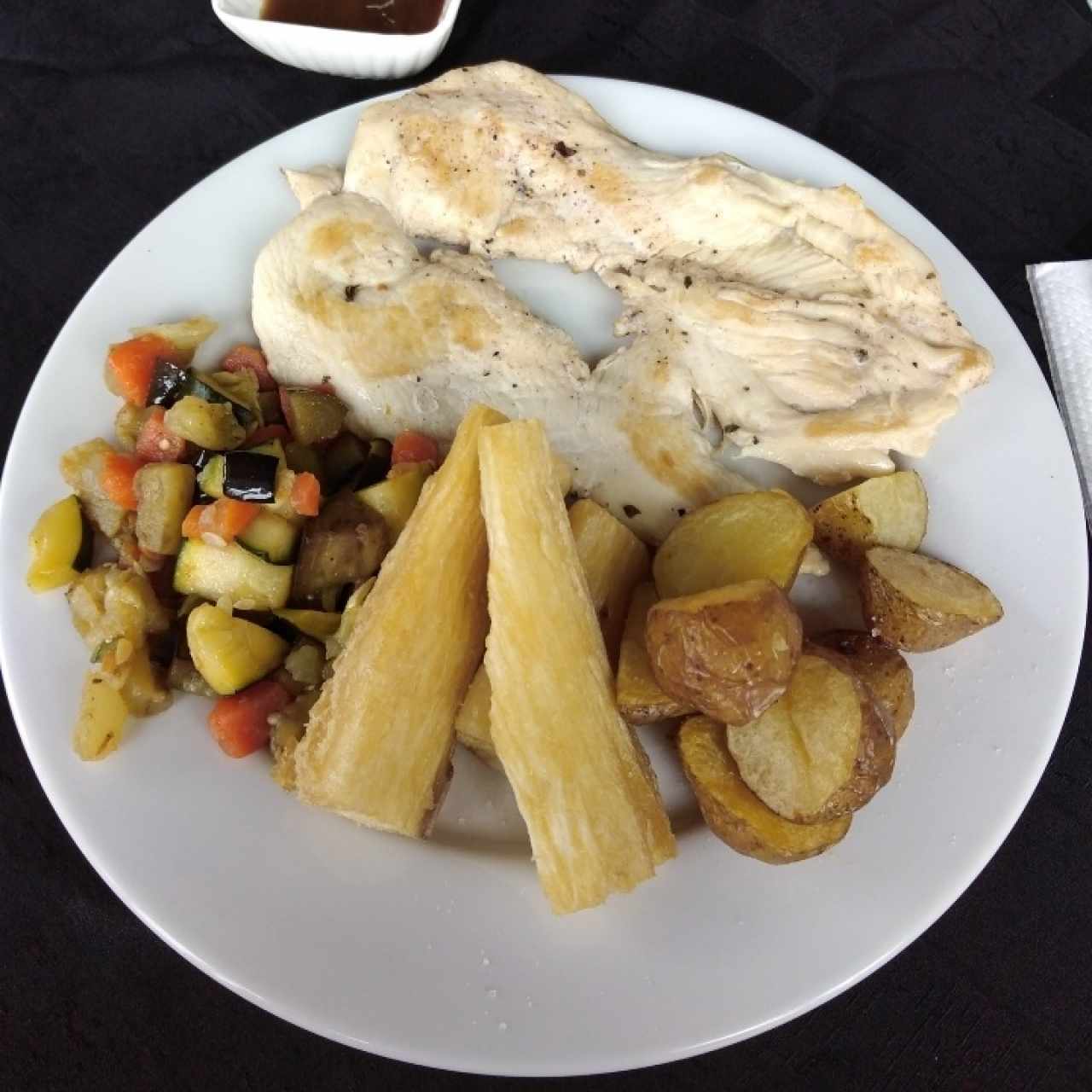 Milanesa de pollo, yuca frita, vegetales salteados y papas