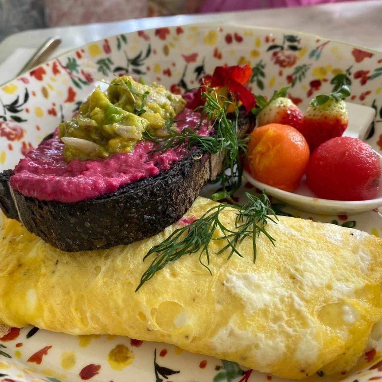 Clásico Omelette con Pan de Tinta de Calamar, Salsa de Remolacha y Aguacate, y Frutas