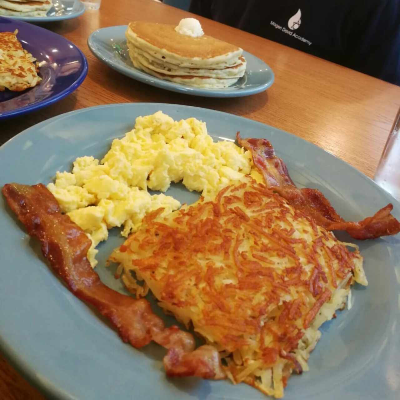 Huevos revueltos con bacón y hash browns.