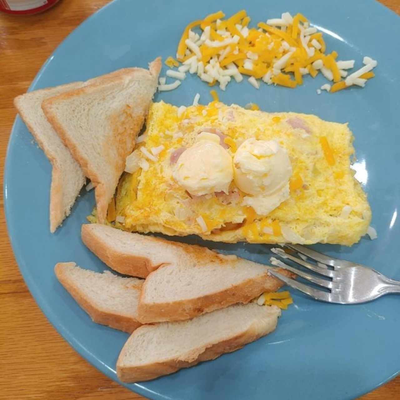COUNTRY OMELETTE (Deliciosa combinación de jamón, queso, cebolla y papa hash browns, cubierto con crema agria)