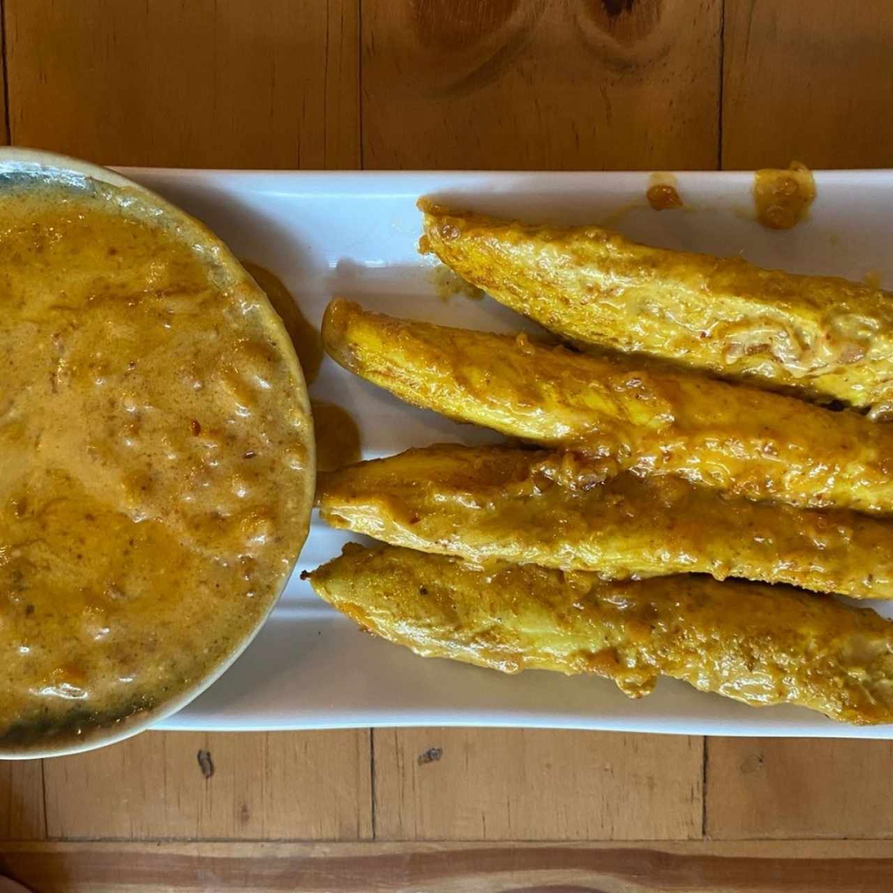 Entrada de brochetas de pollo en deliciosa y abundante salsa de maní. 