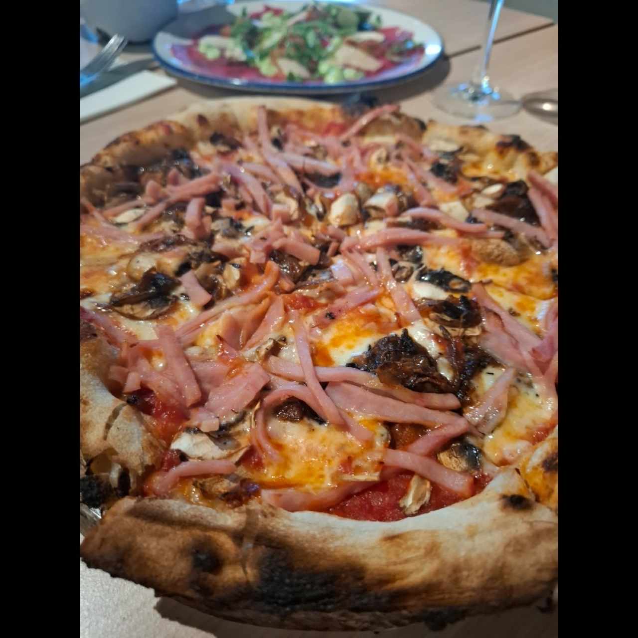 Pizza de jamón y hongos con extra de cebolla caramelizada.