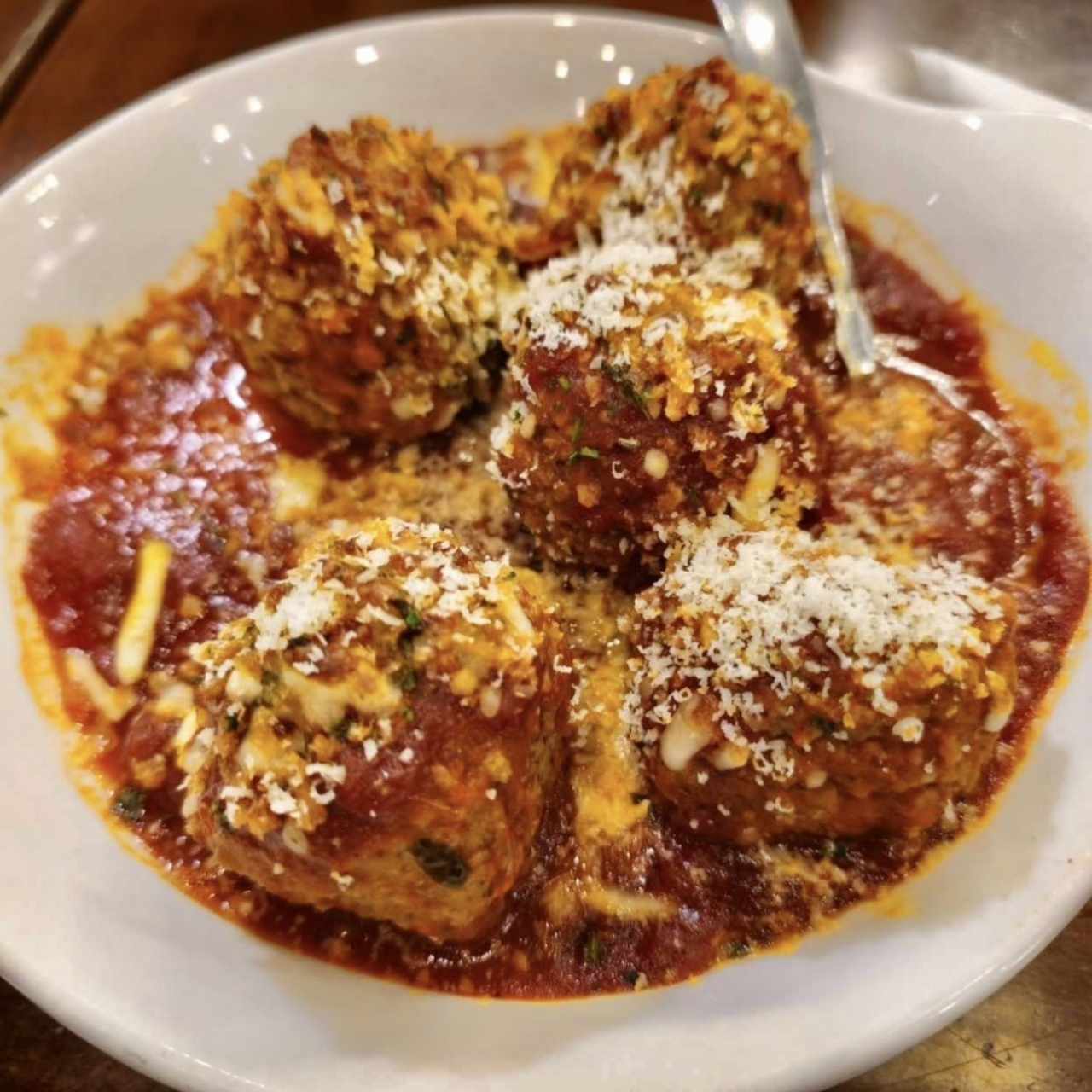 MEATBALLS PARMIGIANA (Cinco Abundantes Albóndigas Horneadas en Salsa Marinara de la Casa, Cubierta con Queso Italiano Derretido y Pan Rallado Tostado) 