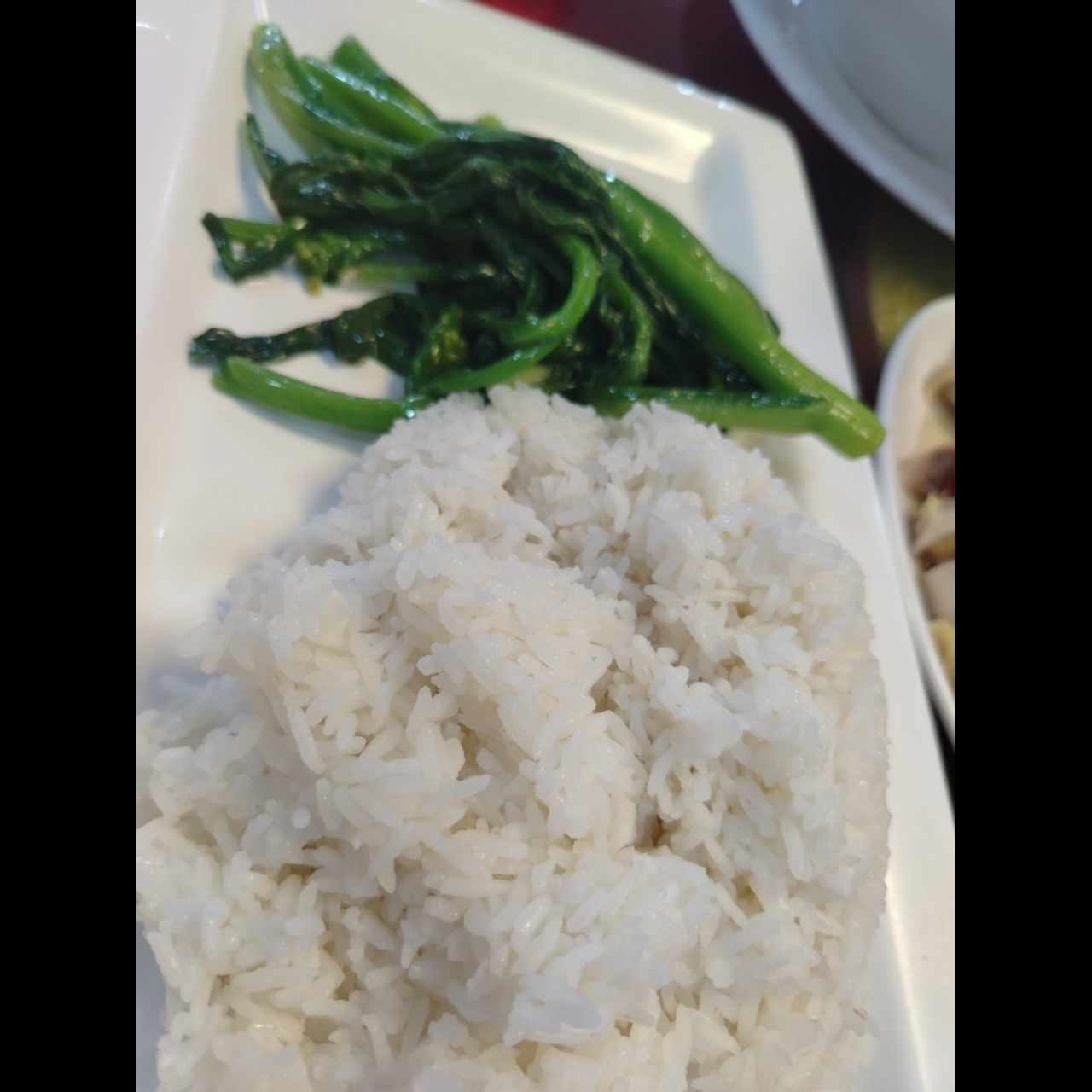 Gallina de patio con arroz blanco y hojas de mostaza 