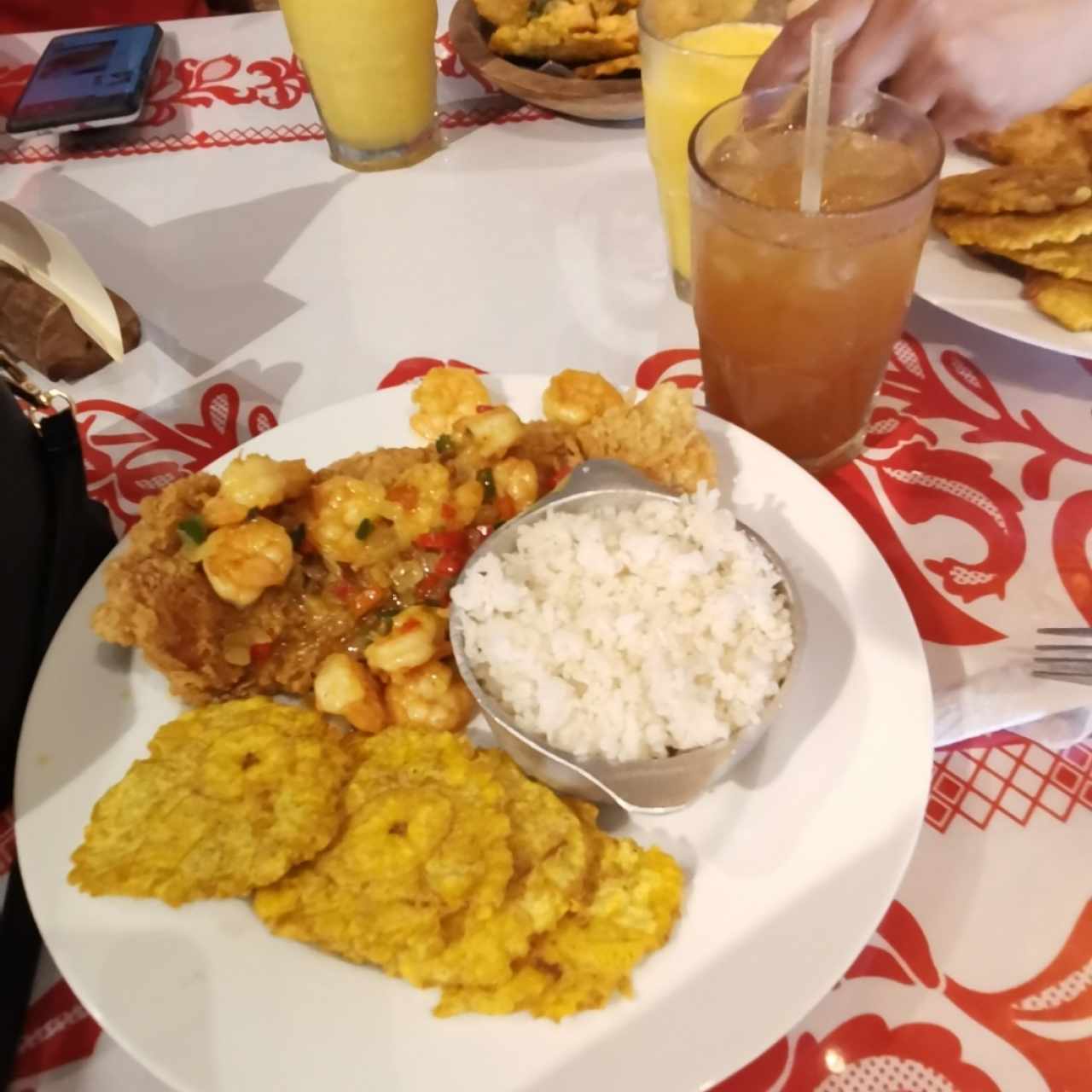 Filete de pescado con corona de camarones con Patacones, arroz con coco y chicha de limón con raspadura 