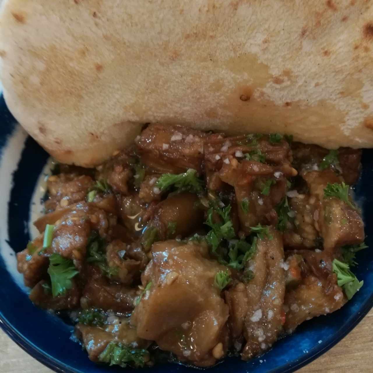 Berenjena frita marinada en aceite de oliva acompañadoa de pan pita