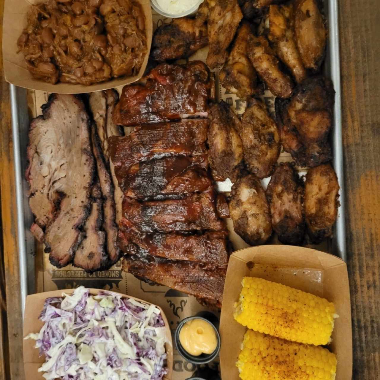 Brisket + Costillas + Alitas ahumadas + frijoles y acompañamiento 