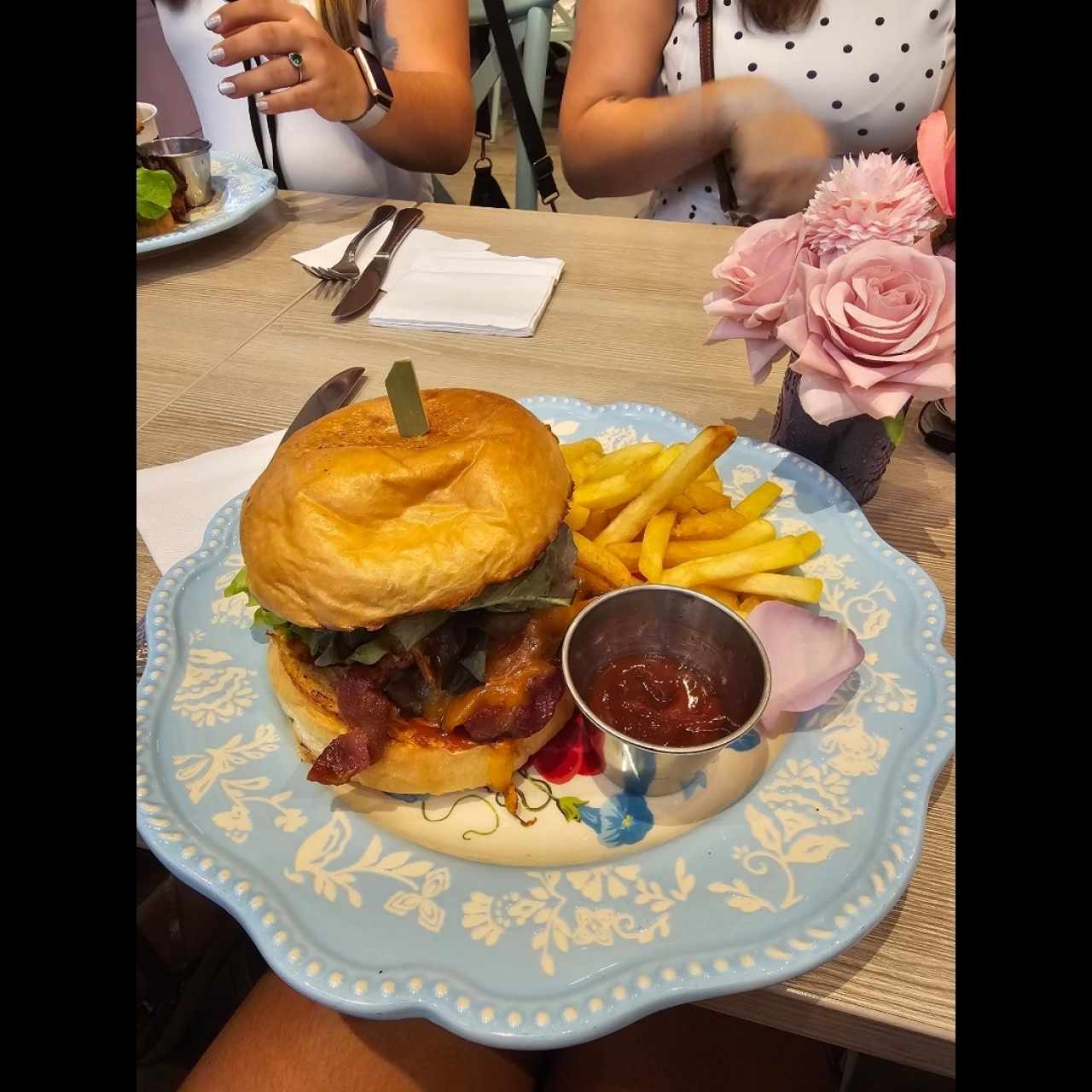 Burger con queso cheddar, cebollas caramelizadas, tomate y papas fritas