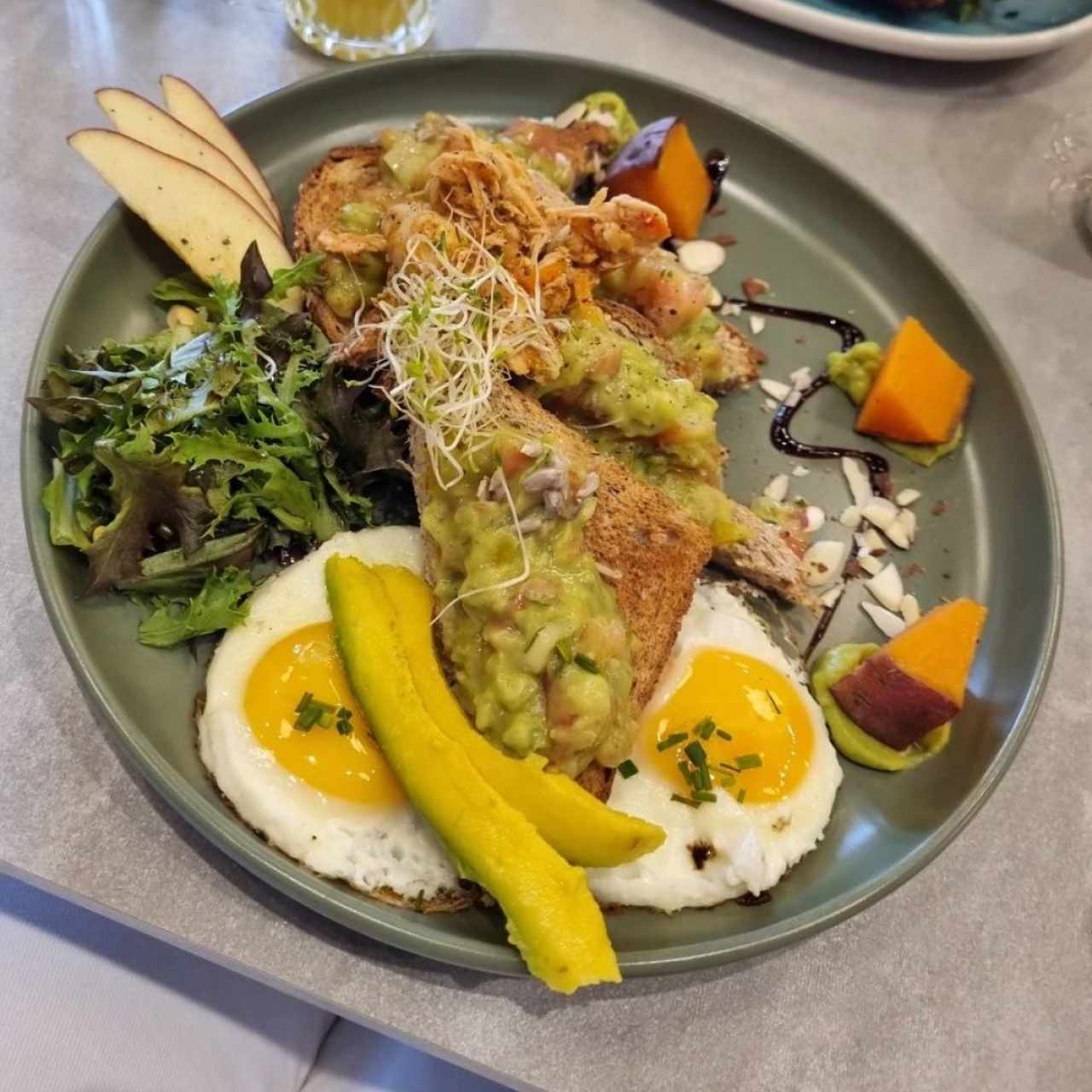 tostadas con pollo mechado y guacamole acompañas de huevo frito y camote 