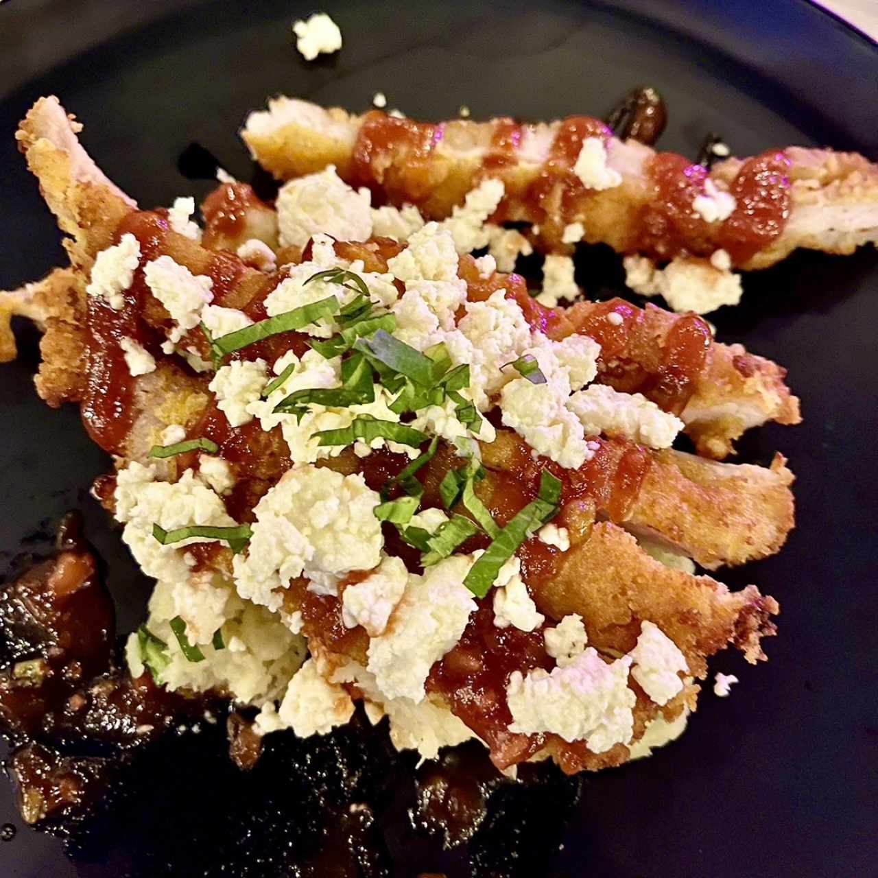 Pollo empanizado sobre puré de yuca