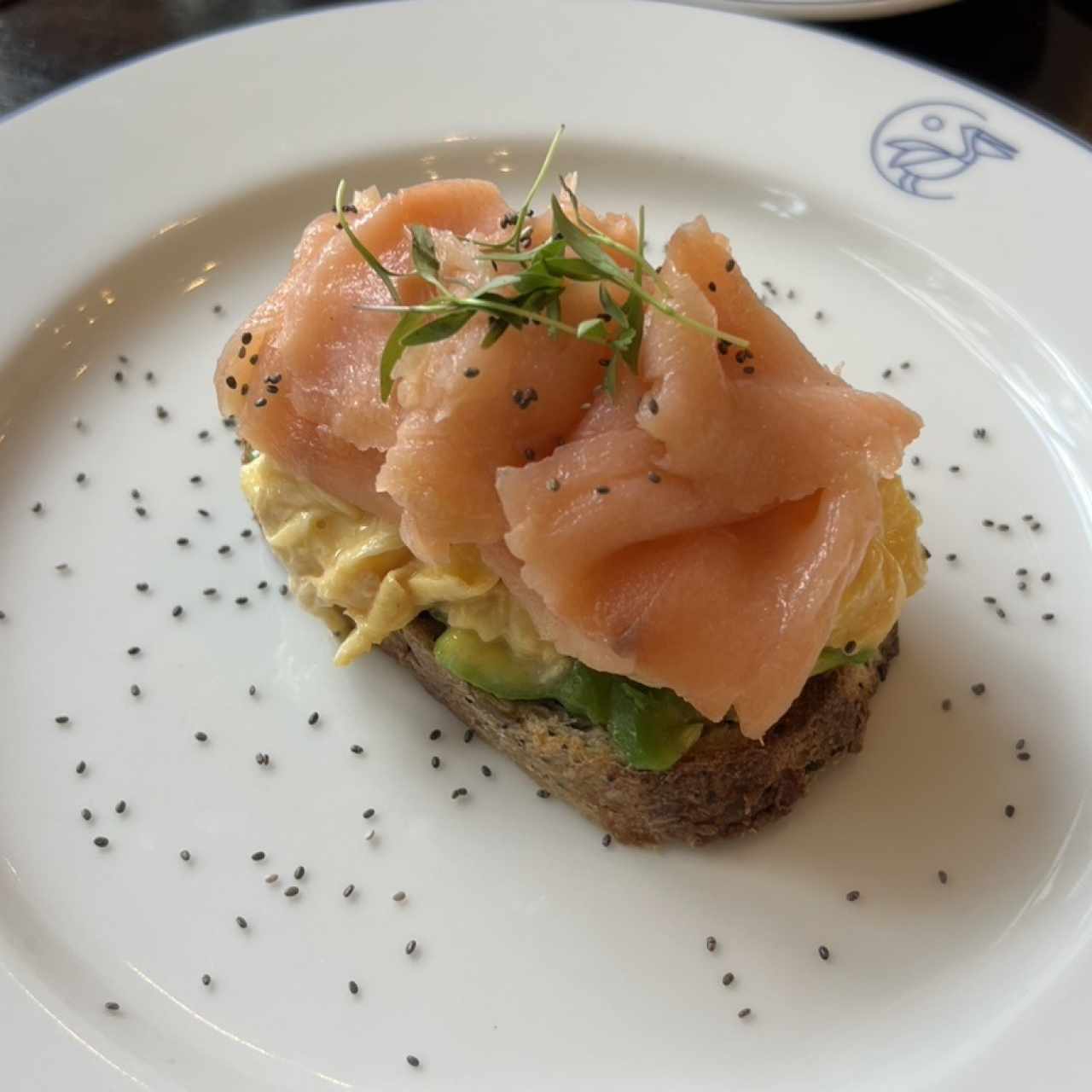 Tostada de Aguacate,salmón ahumado,huevos revueltos y semillas de chía