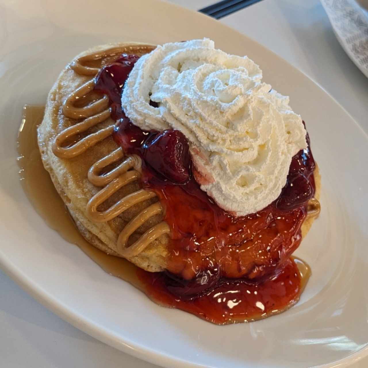pancake con sirope de maple, mantequilla de maní y mermelada de fresa