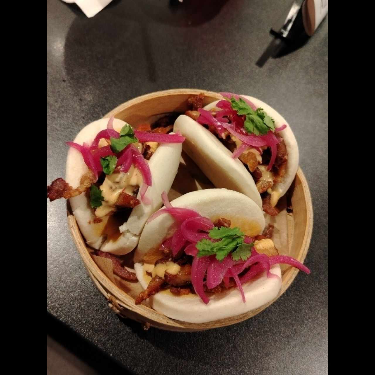 Bao de cerdo ahumado con chicharrón y ensaladilla de sao al estilo panameño, mayonesa de chipotle y encurtido de cebolla