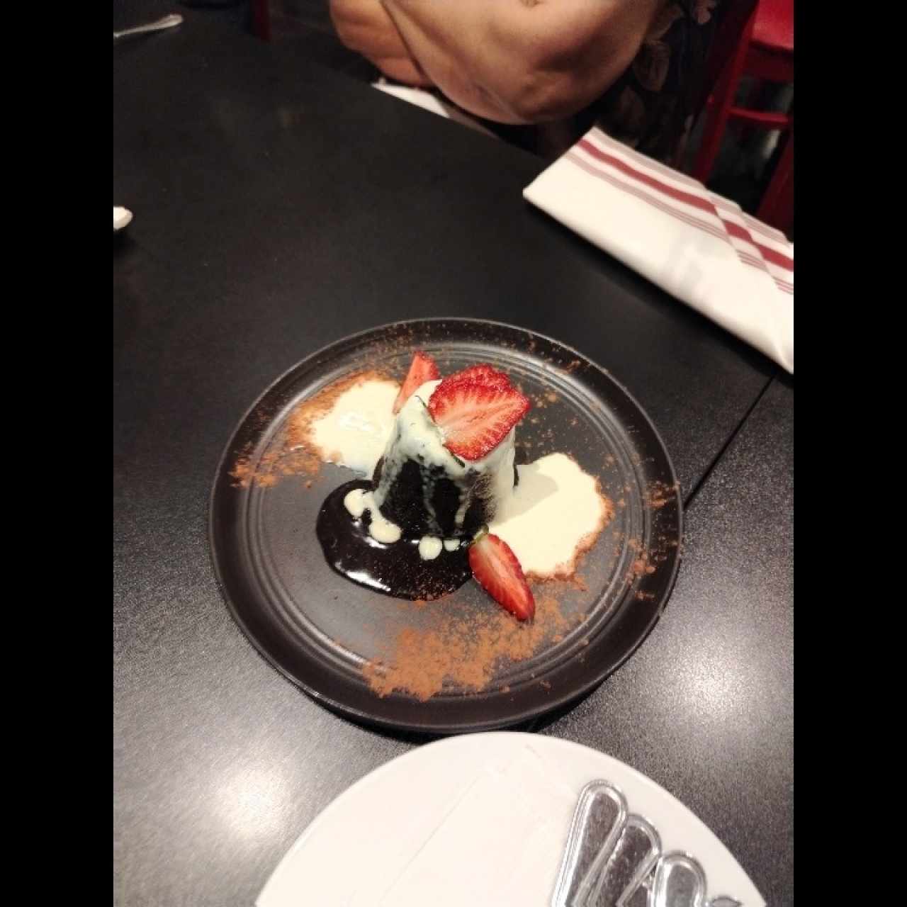 Volcán de chocolate hecho de esponjoso bizcocho relleno de chocolate fundido y acompañado de un quenelle de helado de vainilla
