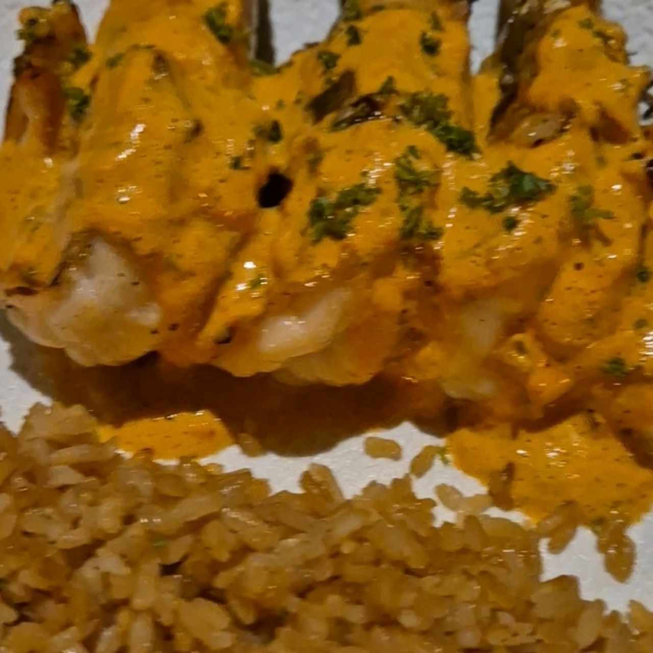 Langostinos en salsa de ají rojo con arroz con coco y raspadura