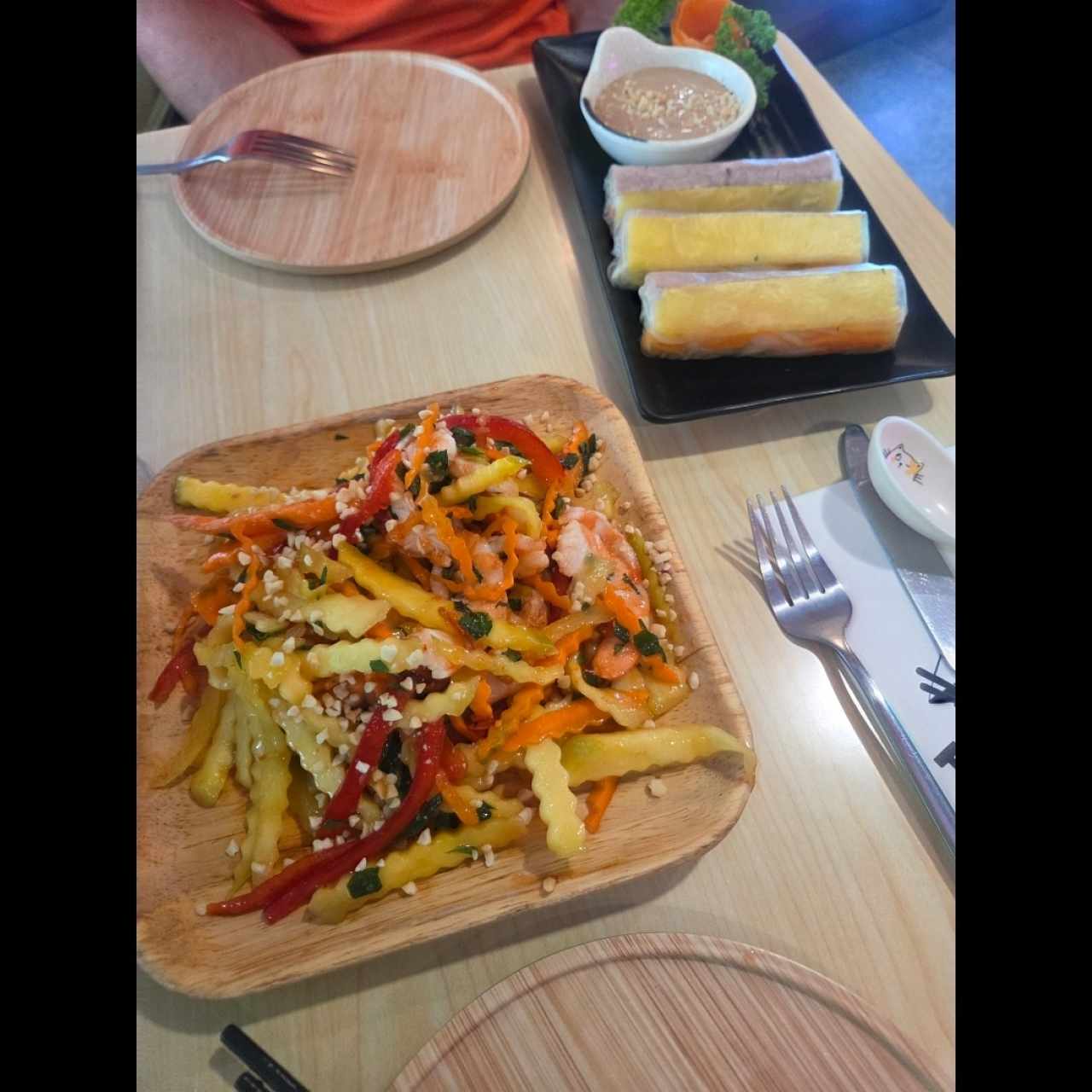 rollos de piña con res  con sala de maní y ensalada mango, pimentón y camarones