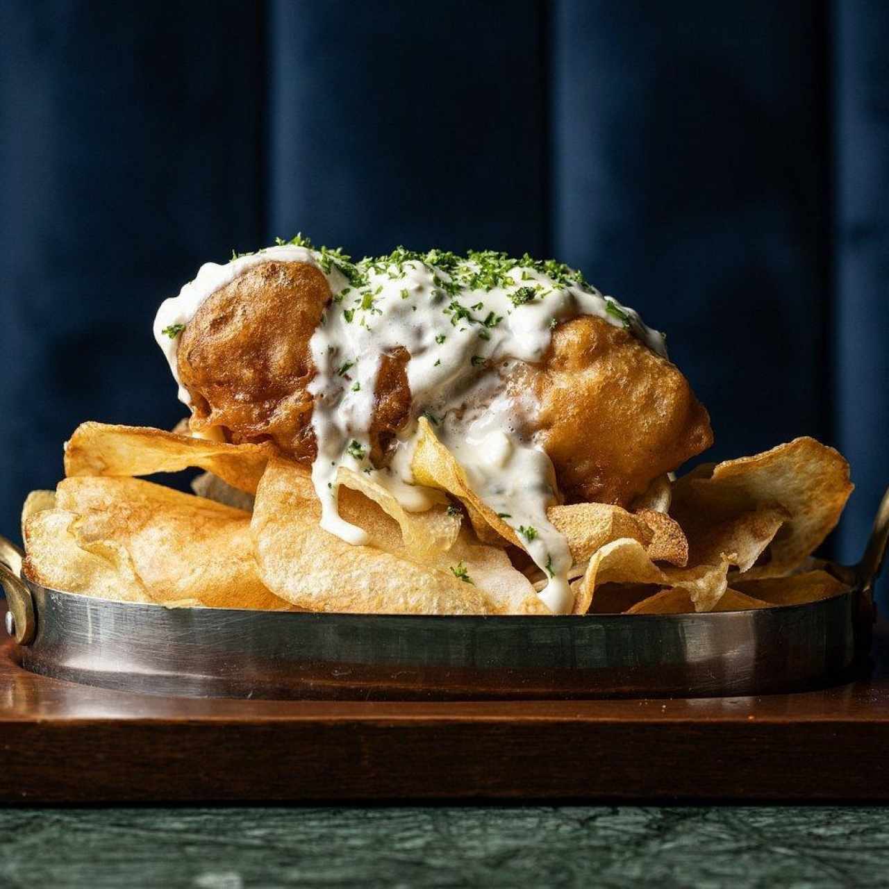 Fish & Chips de pesca del día, chips de papas y trío de salsas