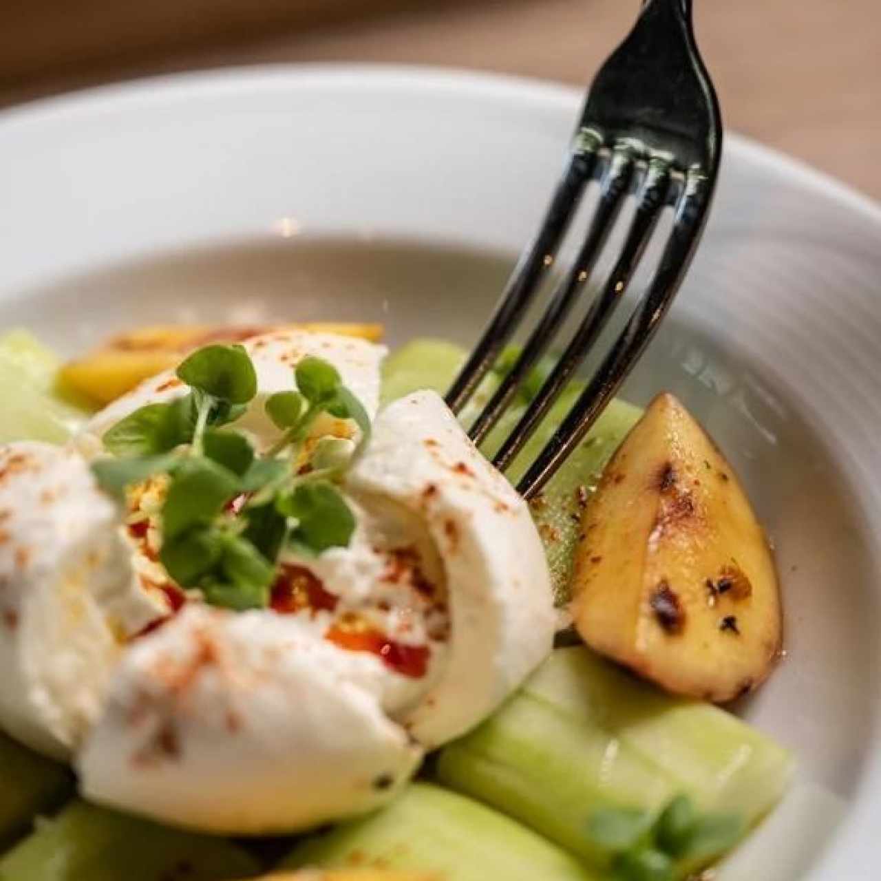 Ensalada de melocotón a la parrilla, burrata, pepino, albahaca y aceite de chiles rojos
