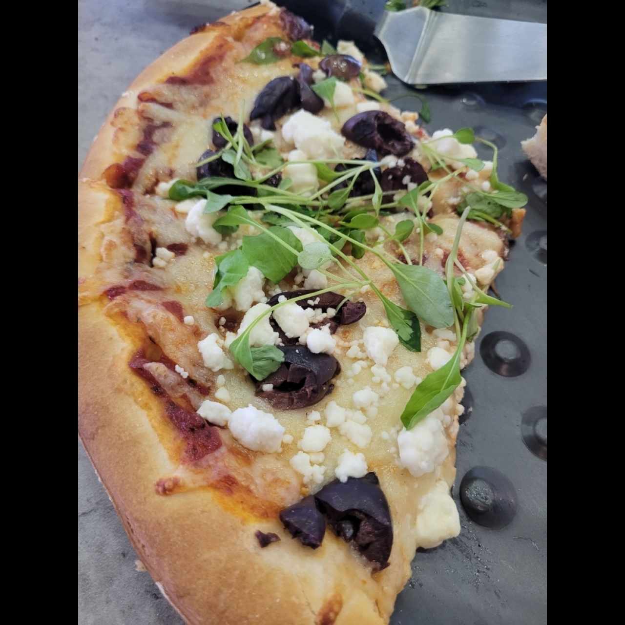 pizza con feta, Kalamata y rugula.