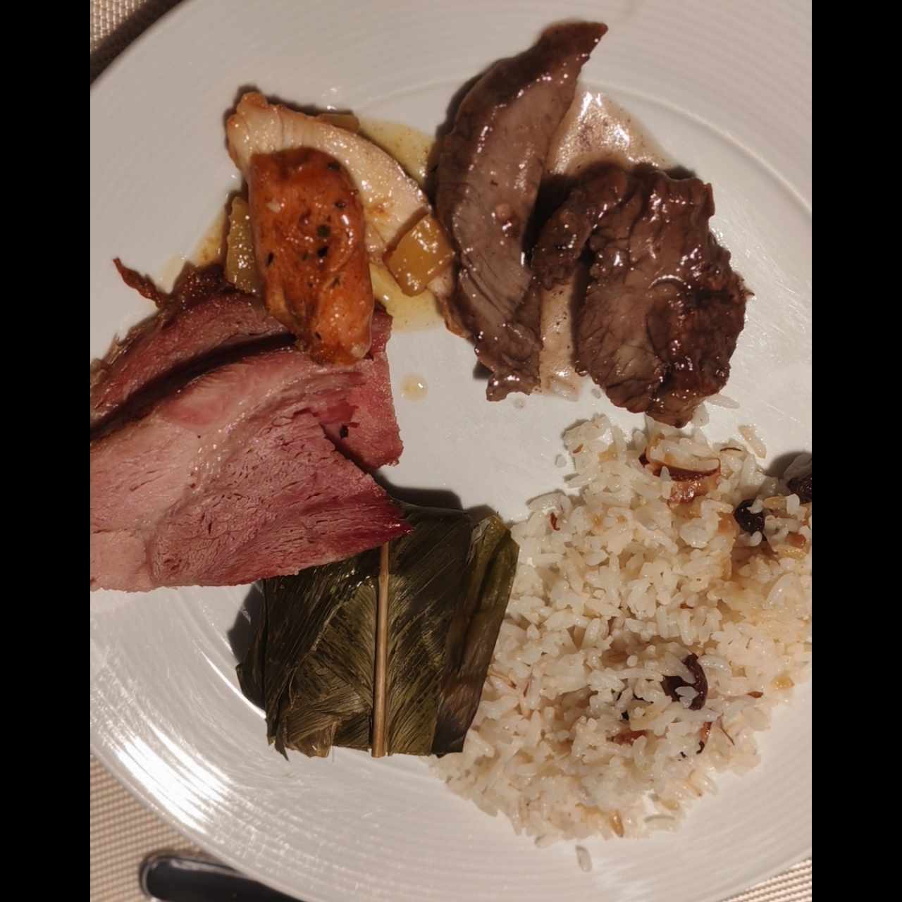 Tamal, arroz de pasas y almendras, jamón glaseado, filete al vino y pollo en salsa de piña 