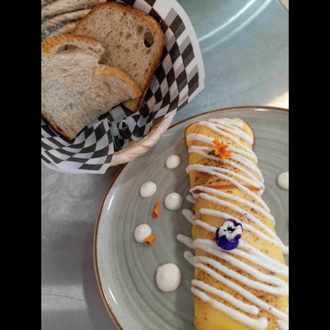Omelet relleno de hongos y espinaca, acompañodo de pan de masa madre. 