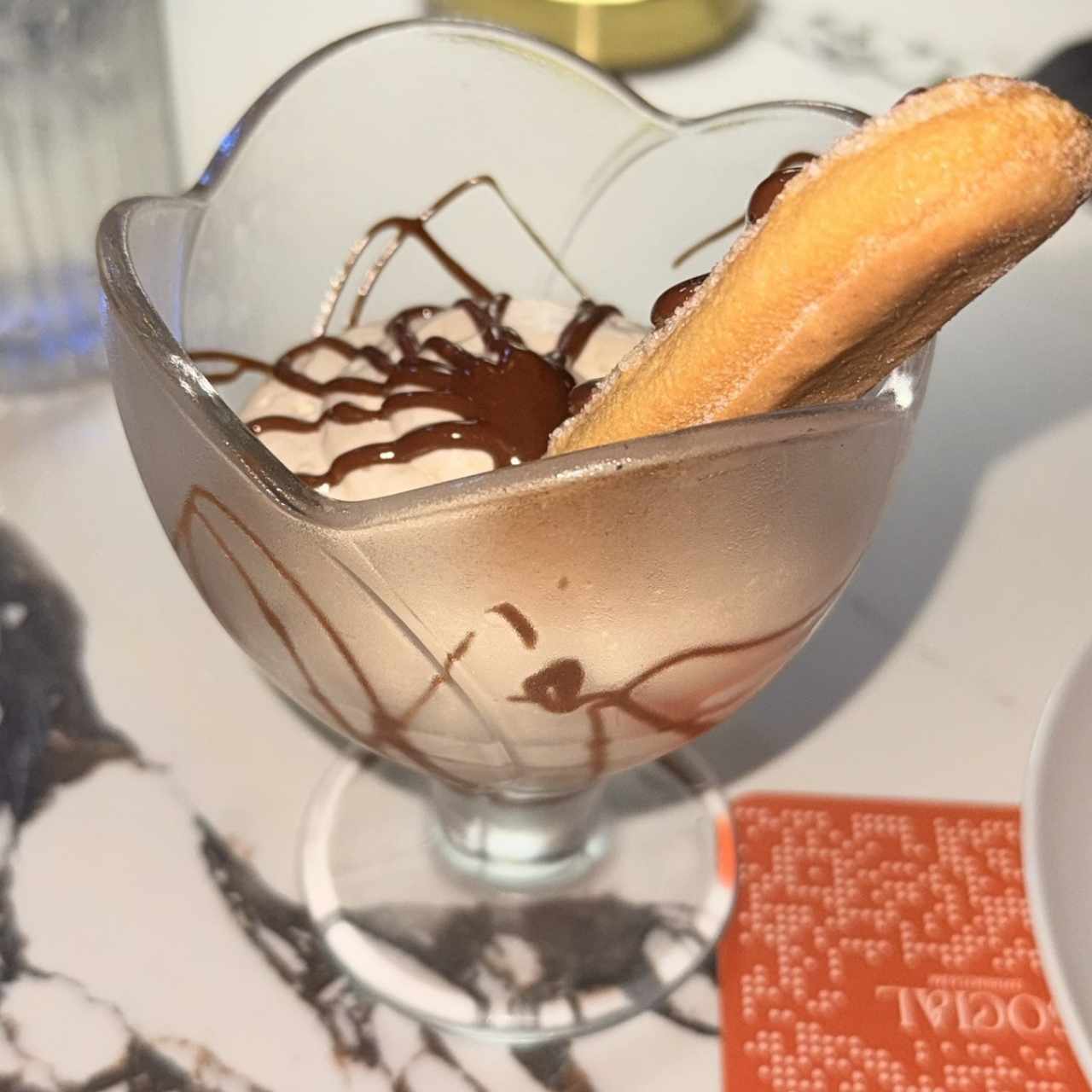 Tiramisú con churro y sirope de chocolate,