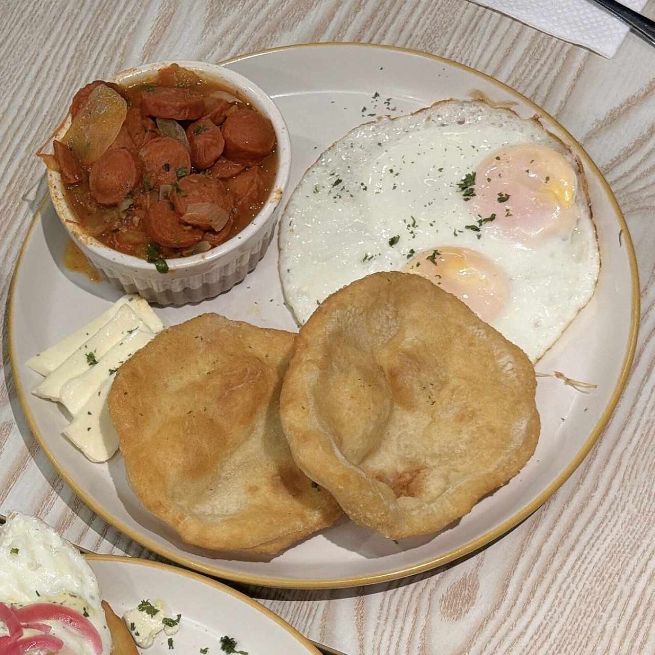 Hojaldre con salchichas guisadas y huevo frito