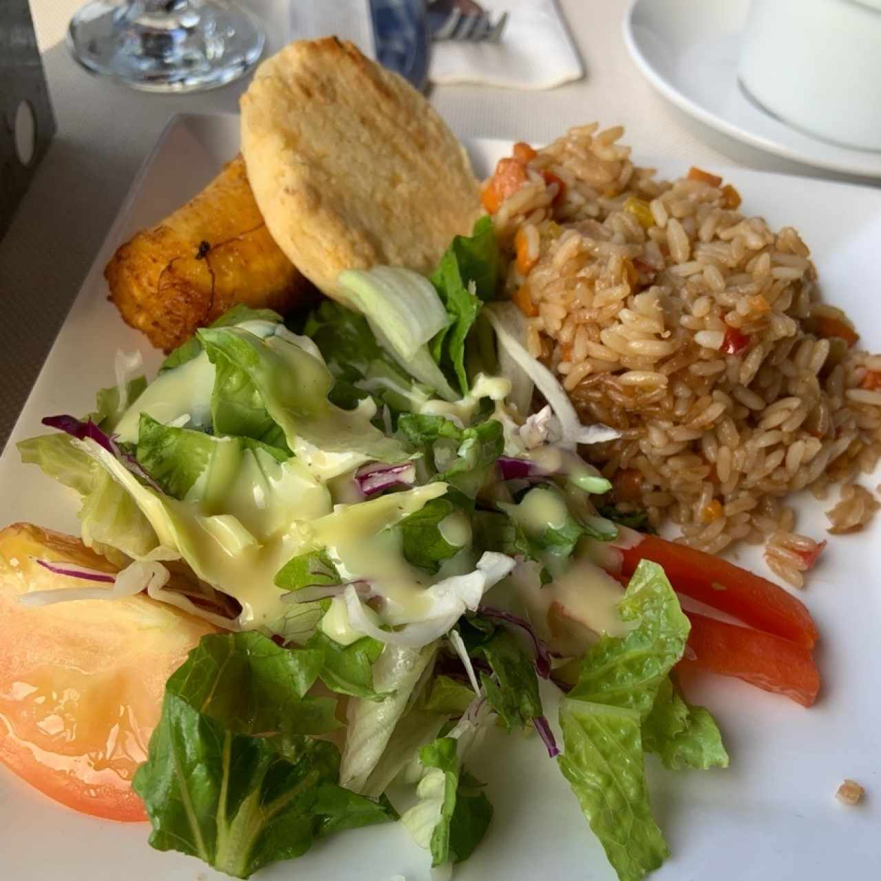Acompañamiento de ensalada, maduro, arepa, y arroz