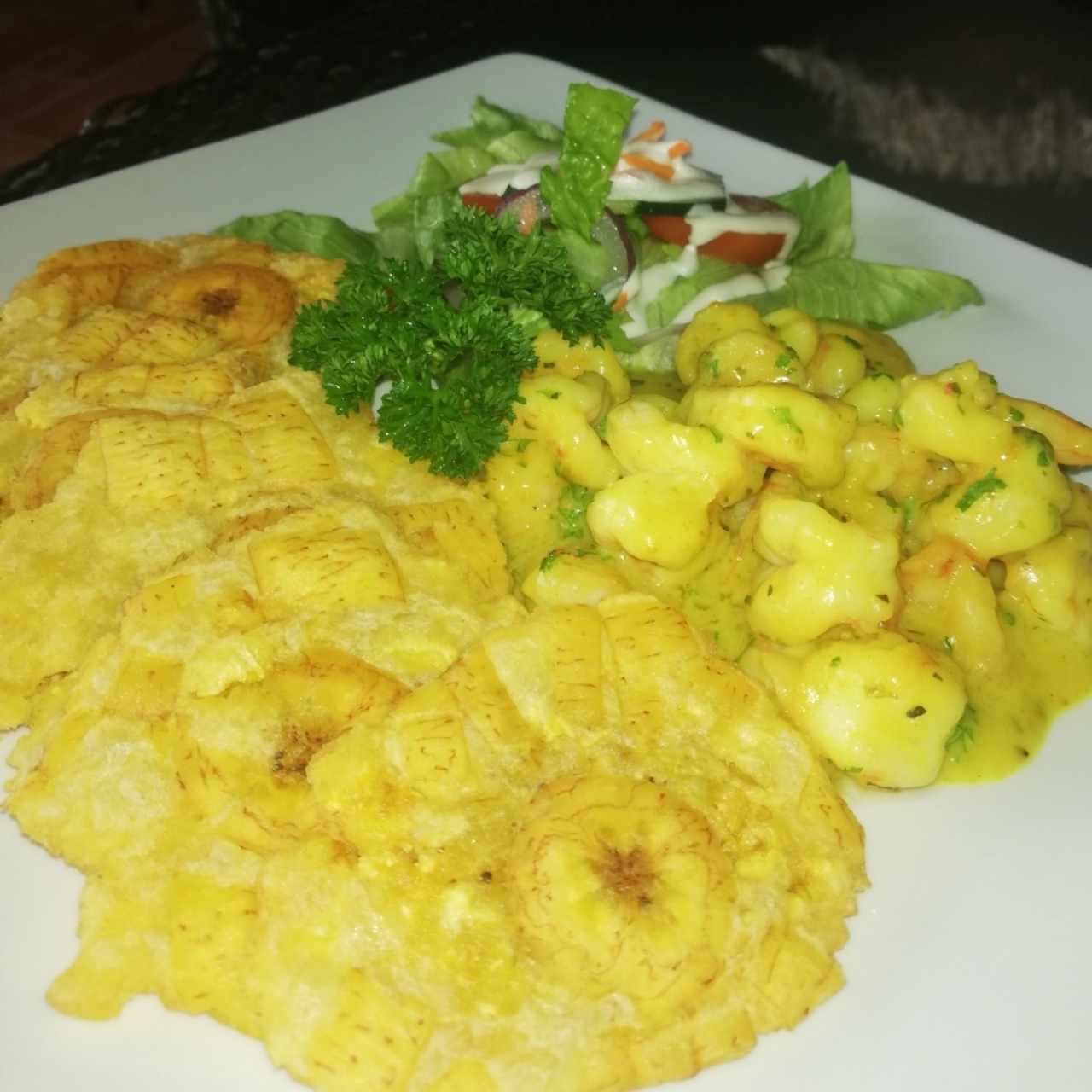 camarones en salsa cremosa de coco y curry acompañados de ensalada del día y patacones