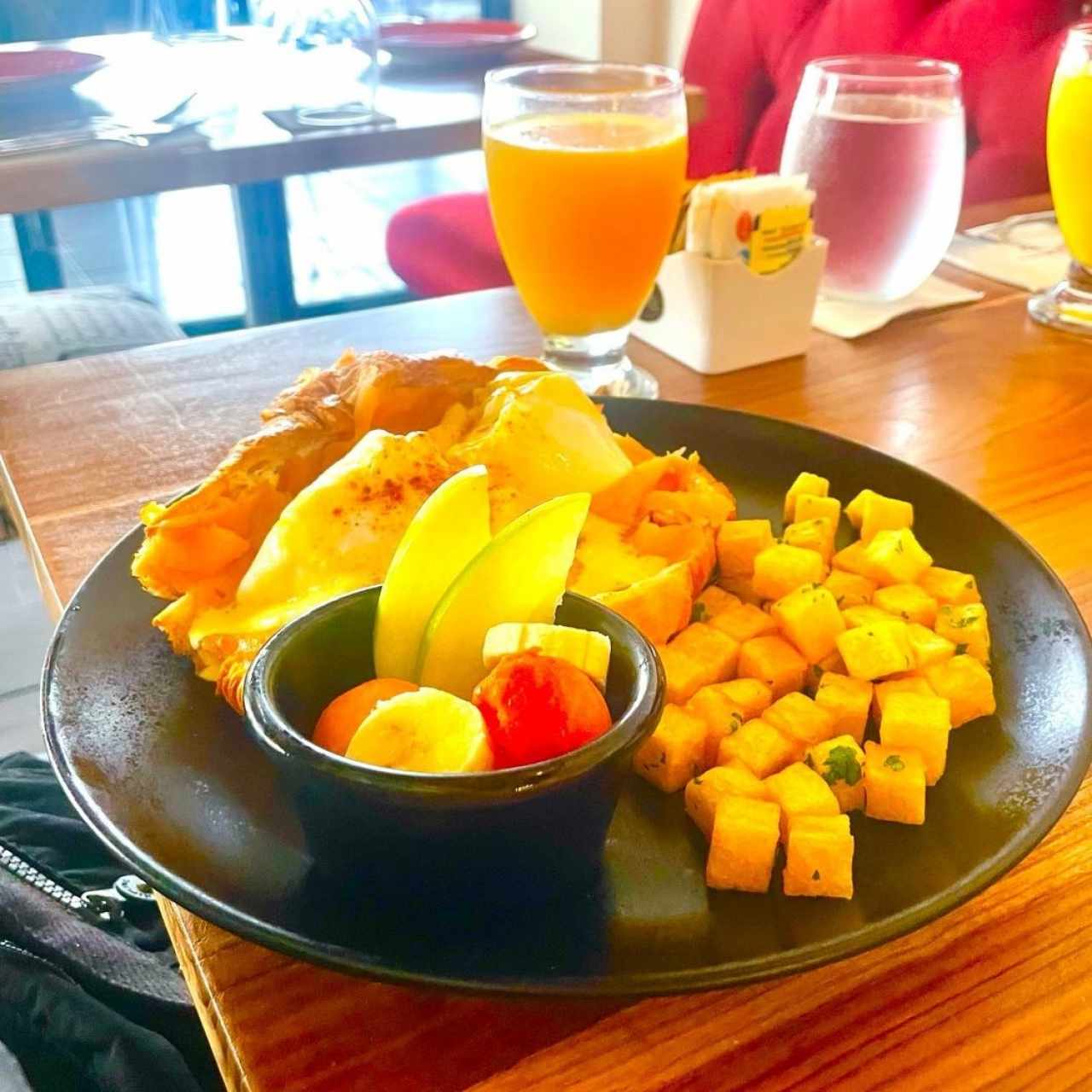 DESAYUNO OEUFS BENEDICT (Huevos Benedict sobre Croissants, Salmón Ahumado, Salsa Holandesa, Papas Salteadas y Ensalada de Frutas)