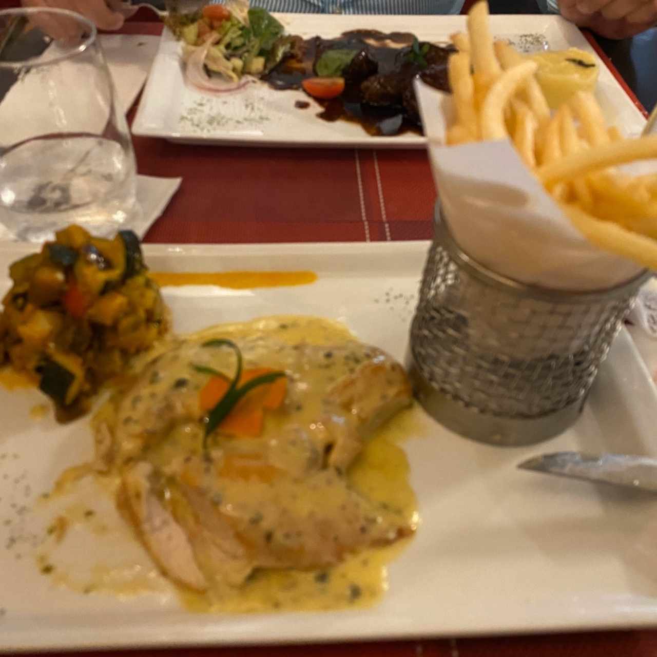 pollo en salsa de pimienta con vegetales Ratatuille y papas fritas 