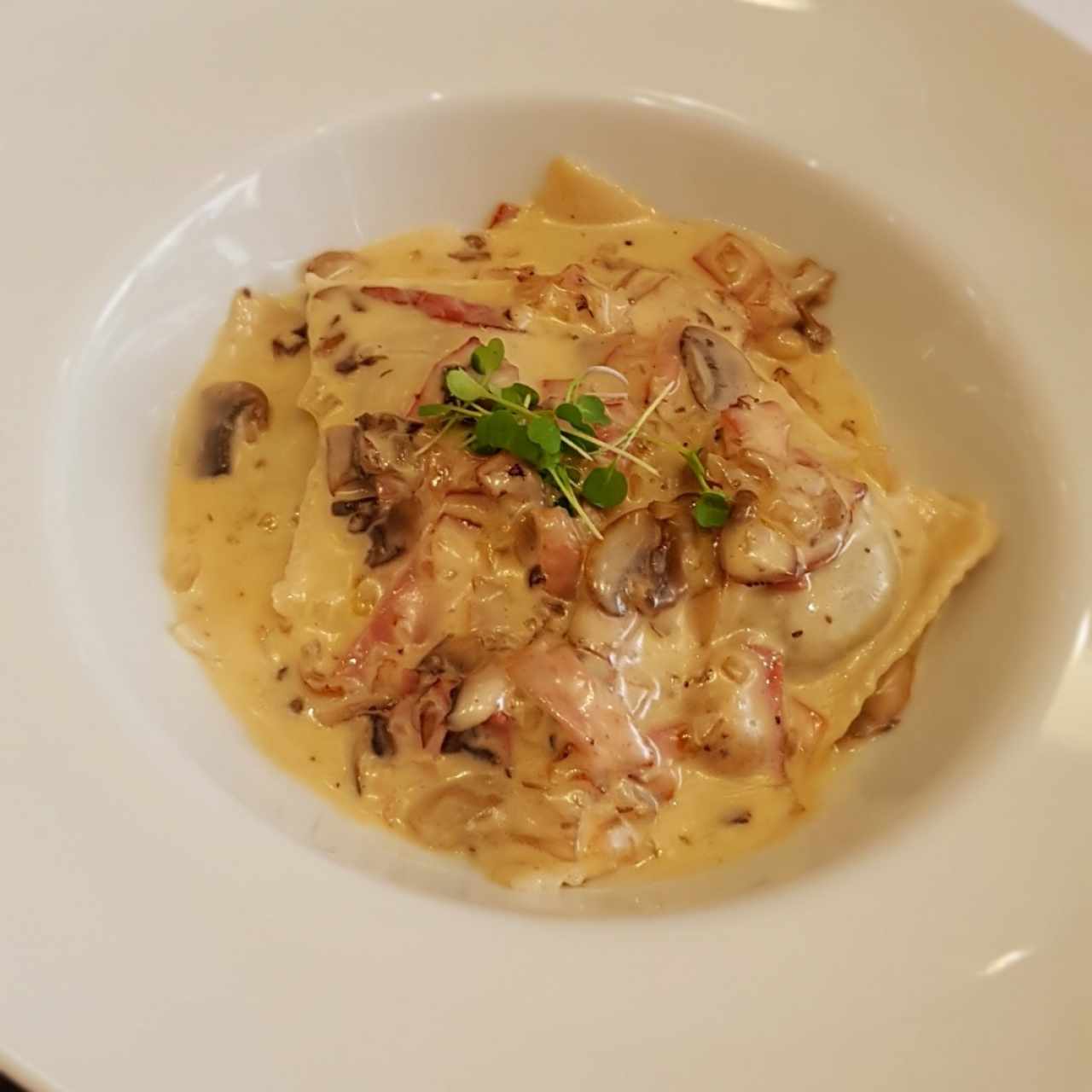 Ravioloni en salsa de hongos y procciutto