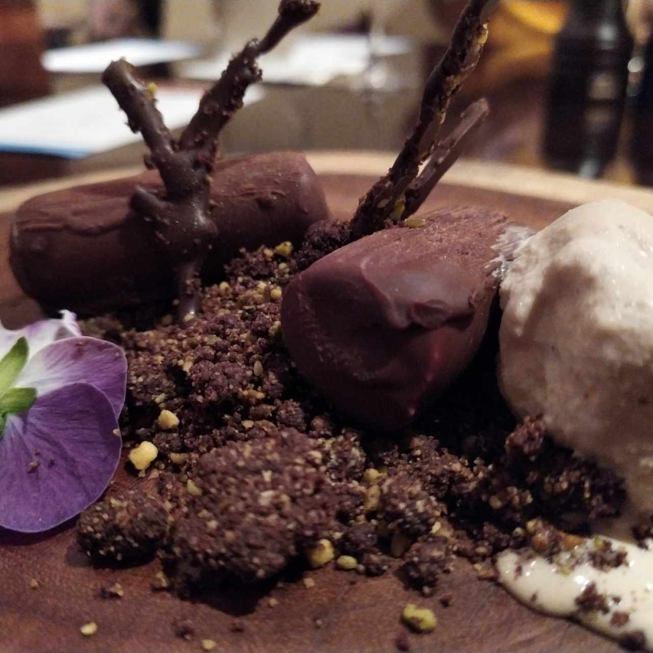 Tierra de chocolate y pistacho, helado de café blanco , confitura de naranja, cheesecake frío cubierto con chocolate y naranja.