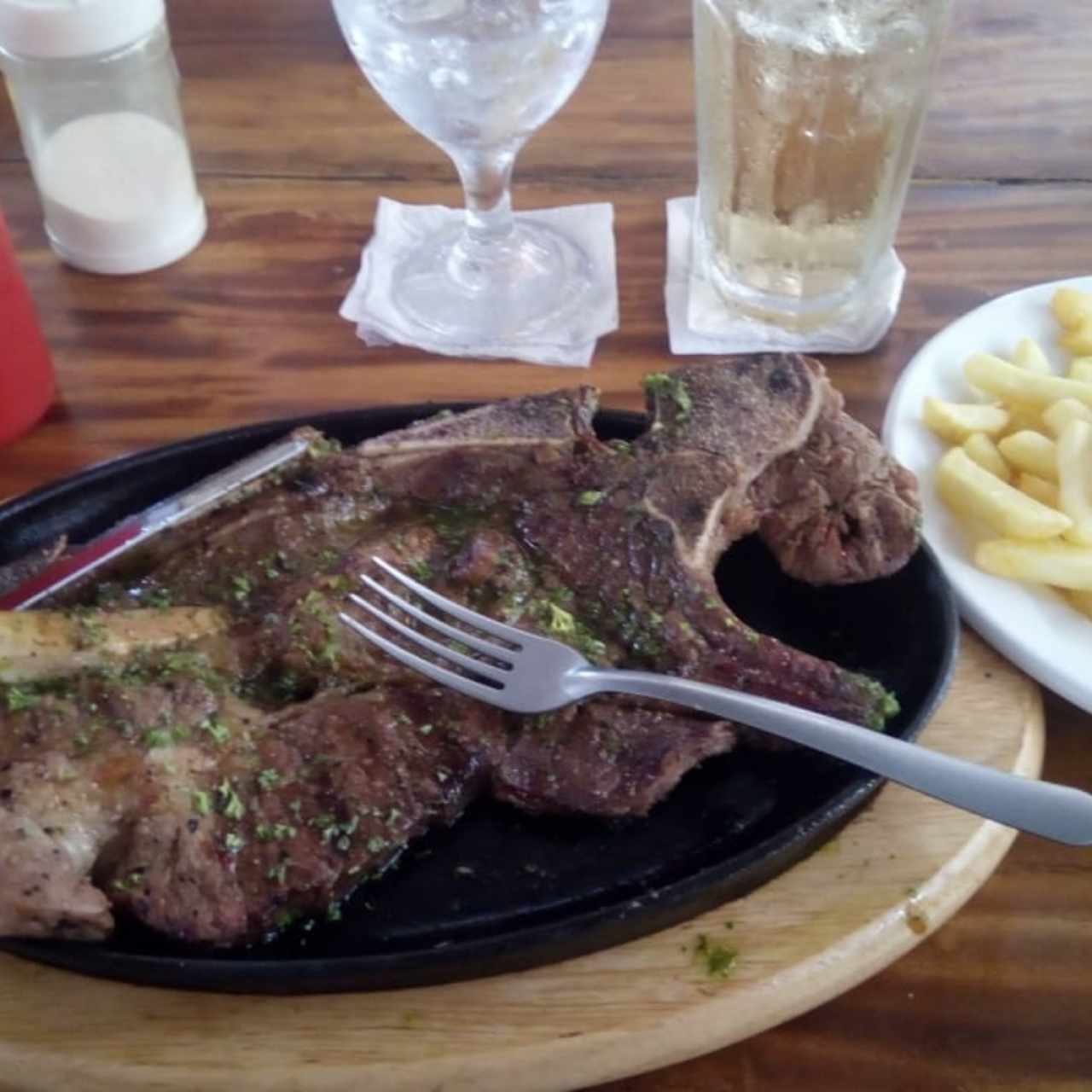 churrasco con papitas fritas y un refresco gingerale