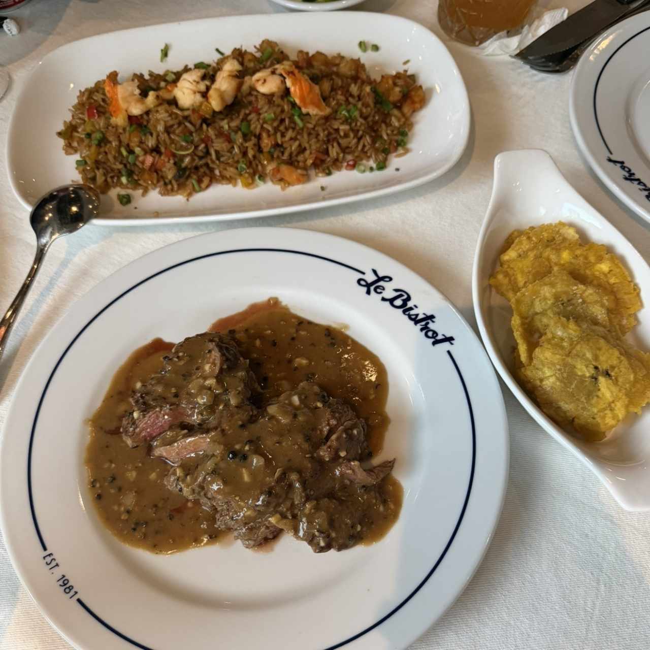 Filete a la pimienta, arroz frito con langosta y patacones 