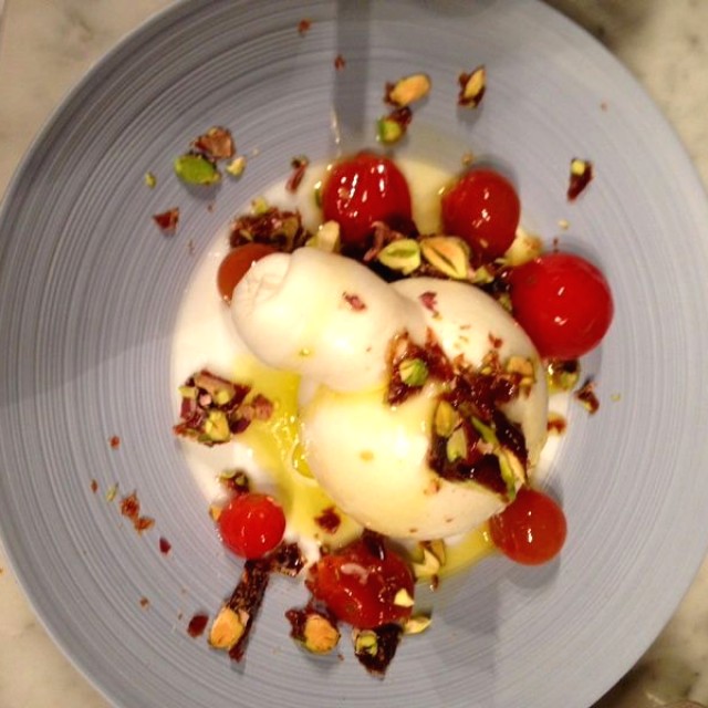 Burrata tibia, praline de pistachos y tomates confitados