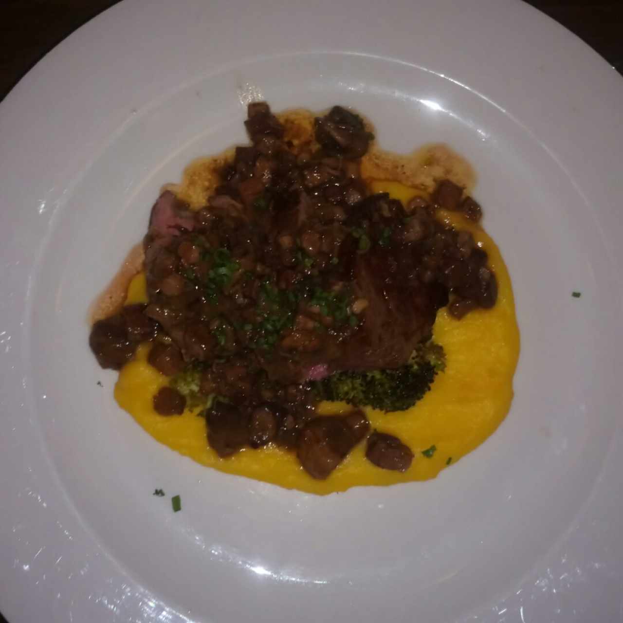 Lomo de res en salsa de vino con puré de papa criolla, champiñones salteados y tocineta