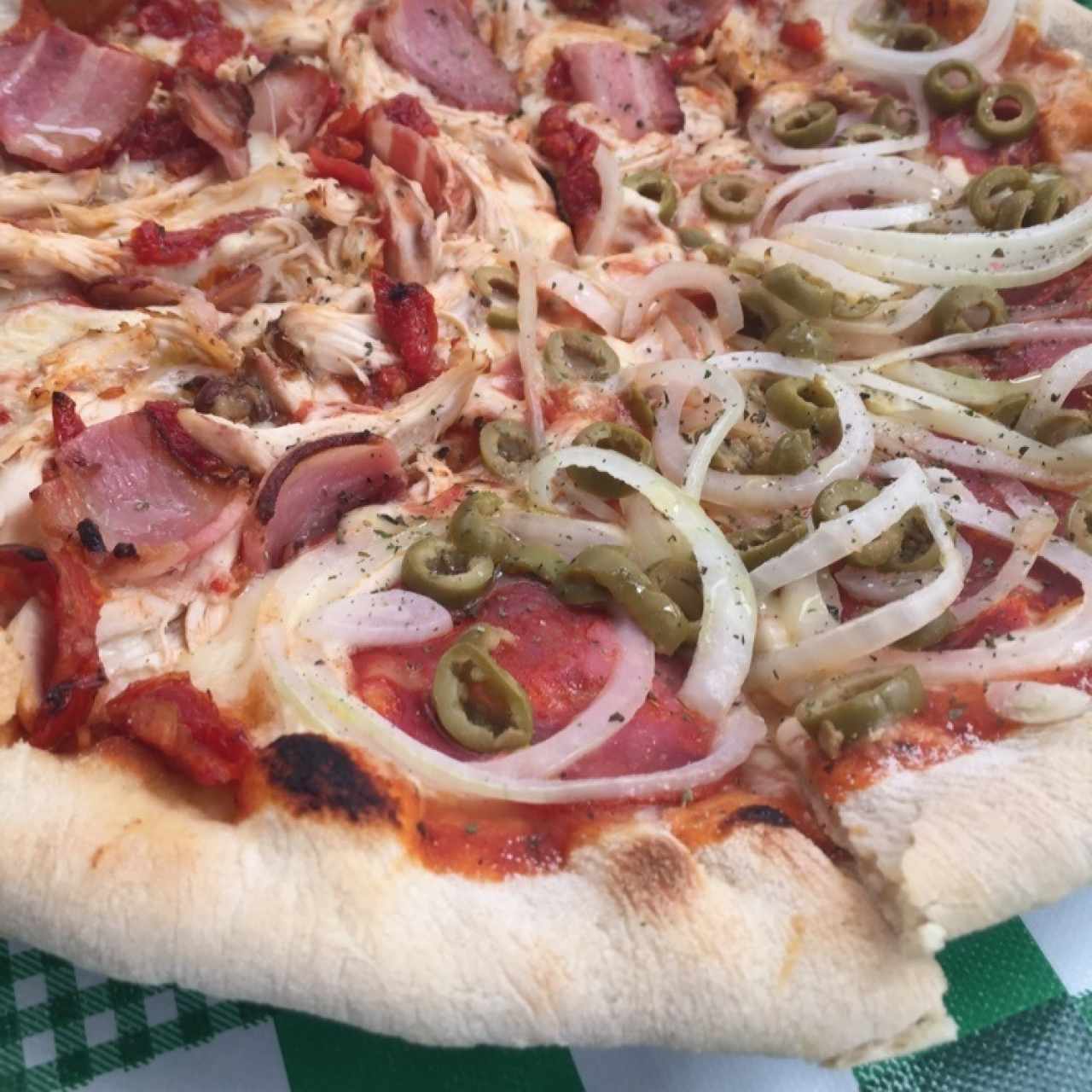 Pizza Pollo, tomates secos, tocineta ahumada / Chorizo español, aceitunas verdes, cebolla 