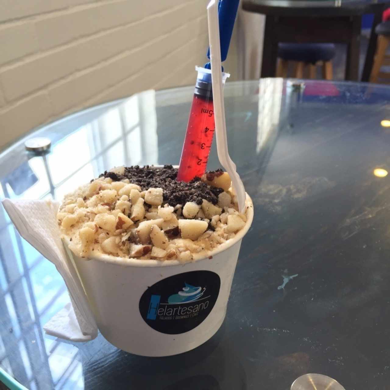 Helado de macadamia con toppings nueces y galleta oreo mas jeringazo de frutos rojos