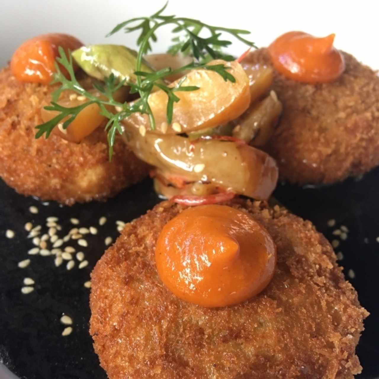 croquetas de pescado en salsa negra (tinta de calamar y coco)