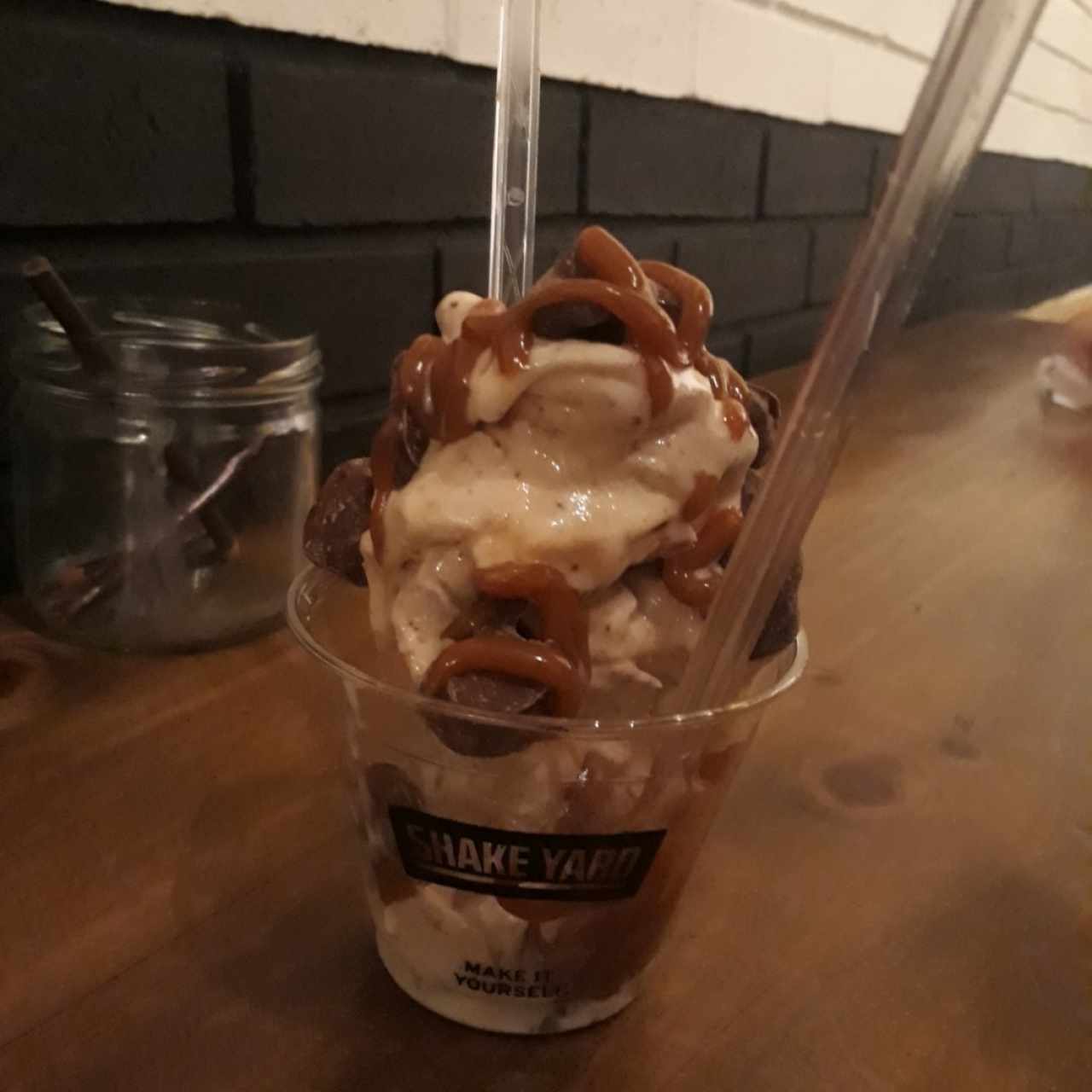 Vaso pequeño, base de vainilla, salsa de arequipe y topping de nuggets de milo