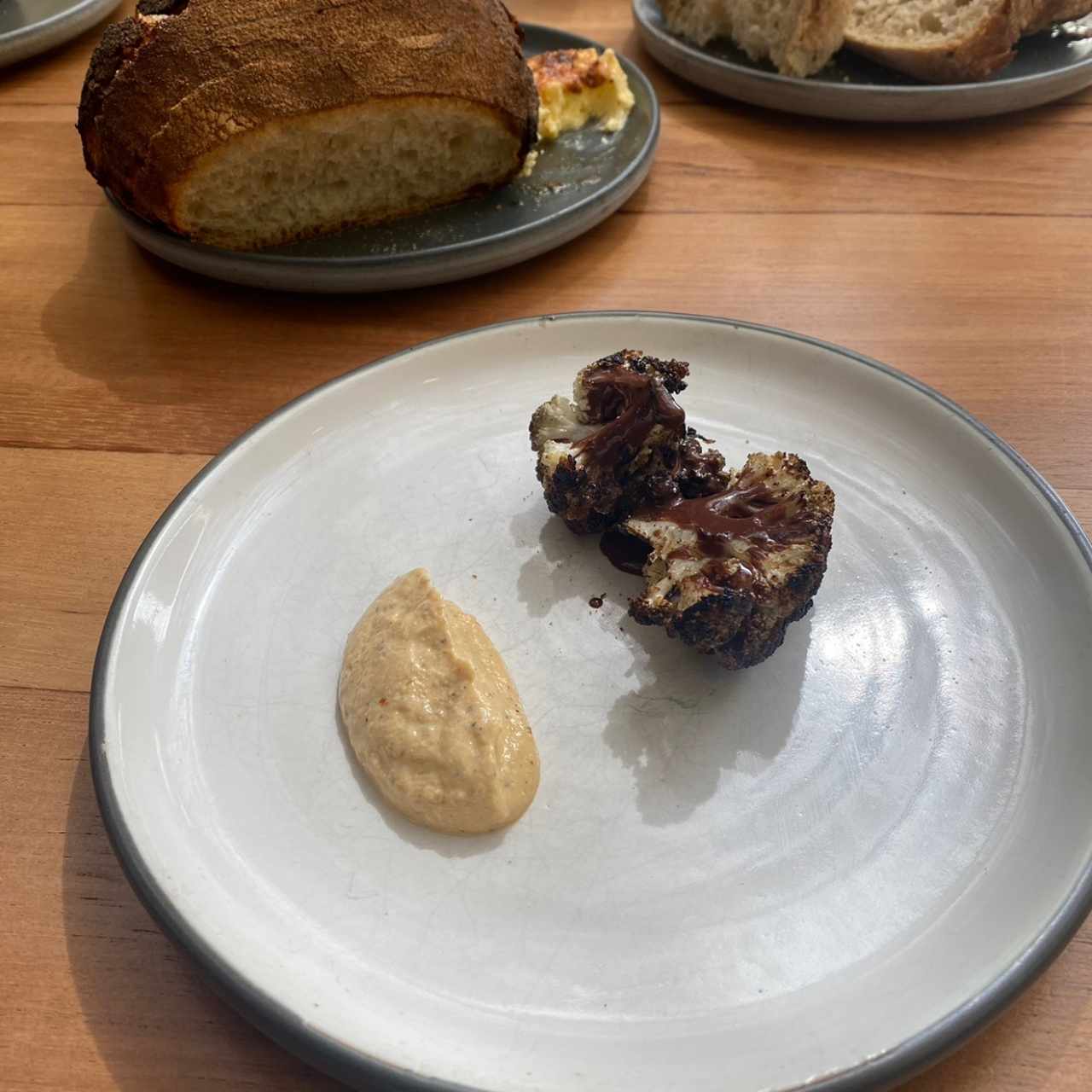 Coliflor grillado en leña, chocolate derretido con aguardiente, y emulsion de Kimchi de ciruelas
